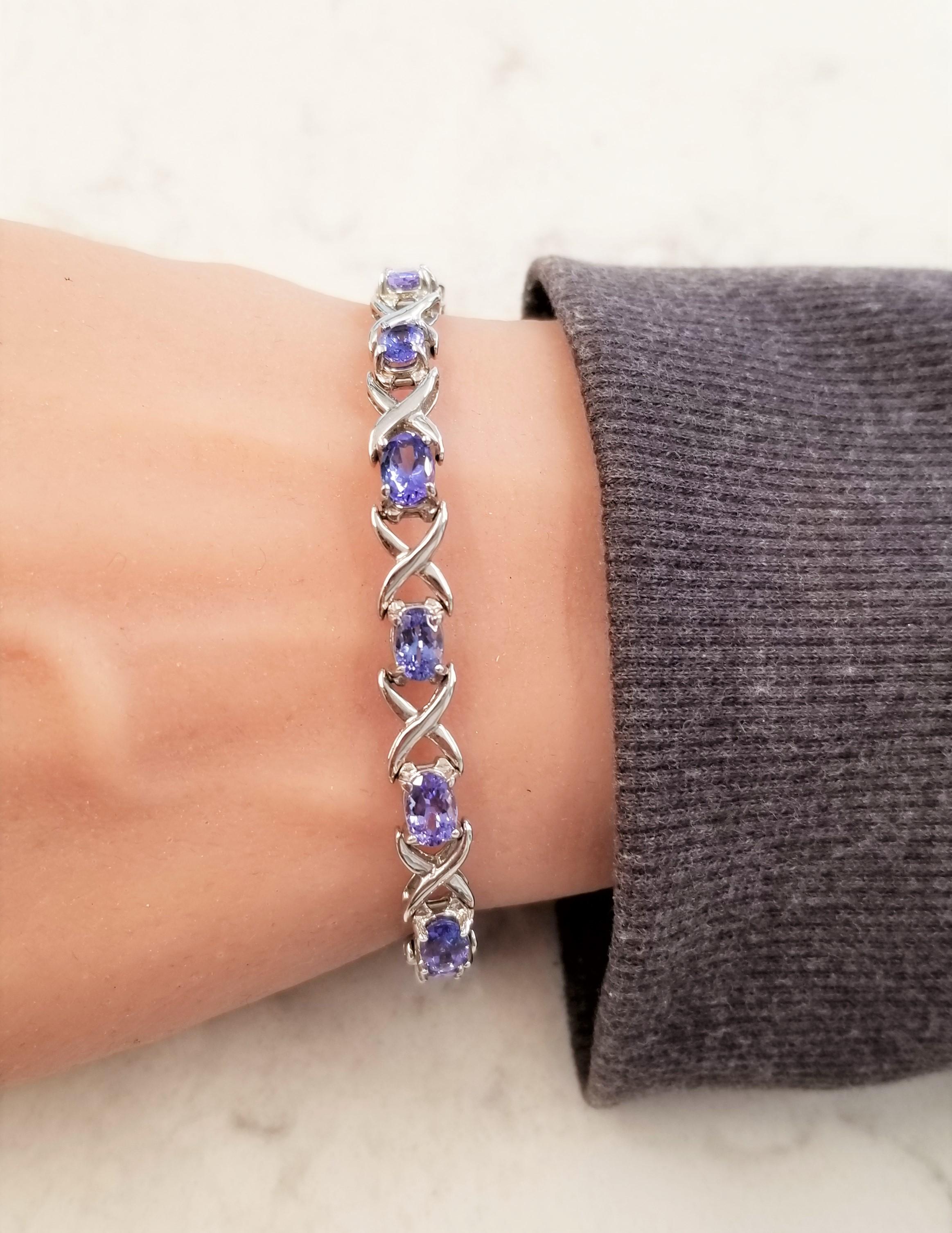 Welcome to the gemstone twist on a love bracelet. Tanzanites laid out in east-west orientation to create this exceptional bracelet. The richly violet & purple gems in a distinctively designed 14 Karat white gold “X” mounting is attractive and