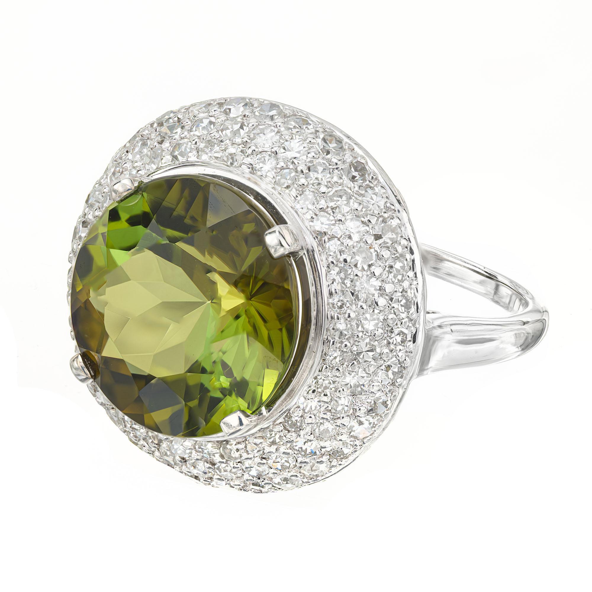 1950's mid-century Tourmaline and diamond cocktail ring. 6.90ct round center bi-color green tourmaline in a platinum setting with a halo of 96 diamonds, totaling 1.65cts. 

1 round green brown tourmaline, VS approx. 6.90cts
96 round diamonds, G-H