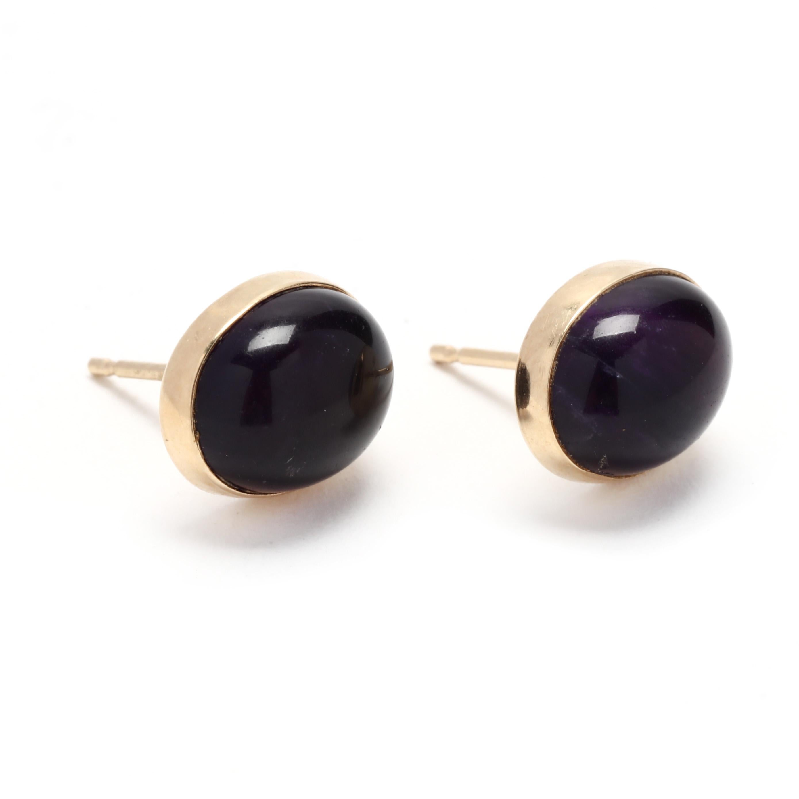 A pair of 14 karat yellow gold cabochon amethyst stud earrings. These February birthstone earrings feature bezel set, oval cabochon cut amethyst weighing approximately 6.90 total carats and with pierced push backs.

Stones:
- amethyst, 2 stones
-