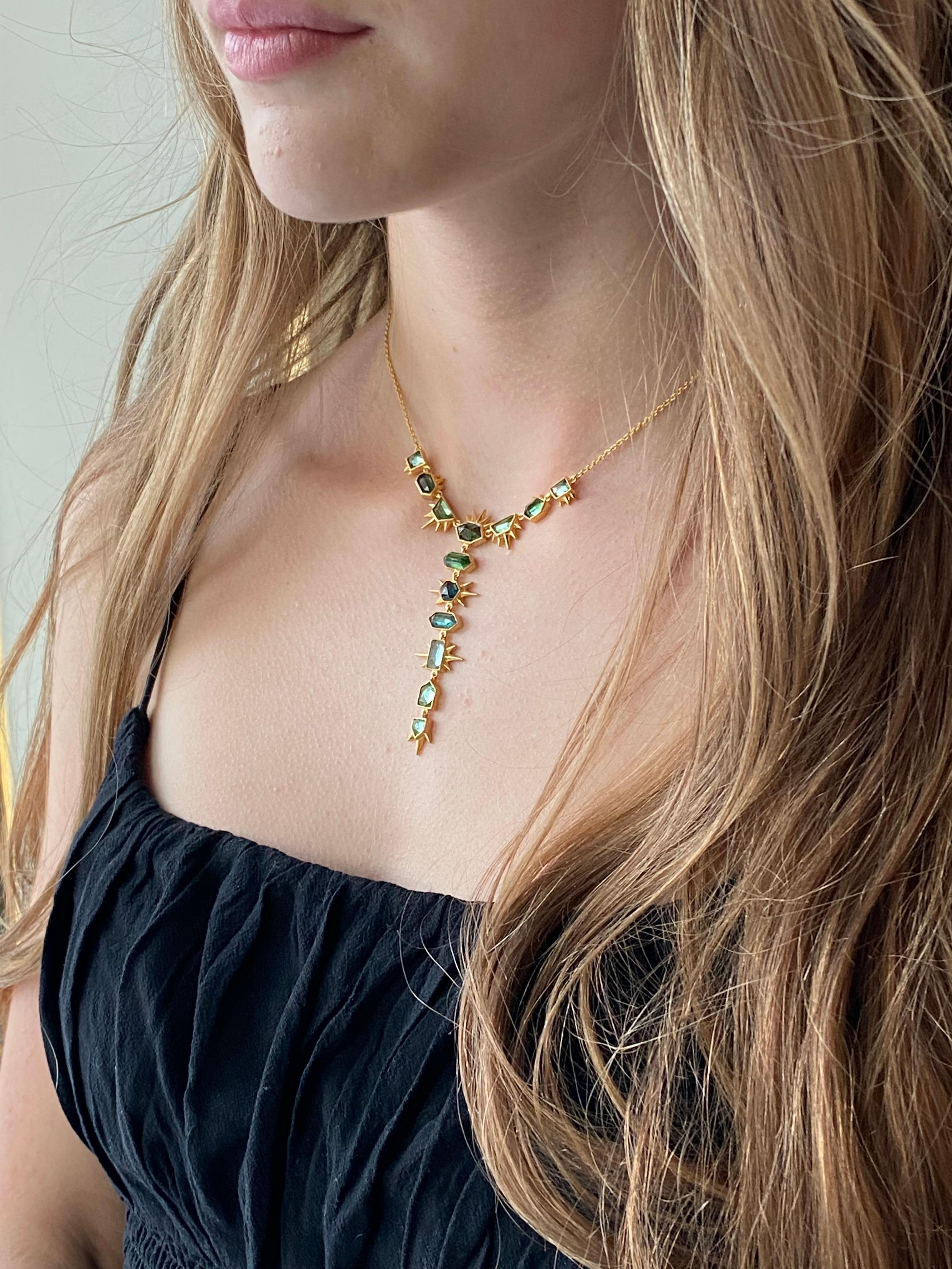 Designed by award winning jewelry designer, Lauren Harper, this spectacular 6.91 carat multi shade Green Tourmaline and 18kt Gold necklace is a stunning addition to any jewelry collection.  Each green tourmaline is a uniquely faceted geometric