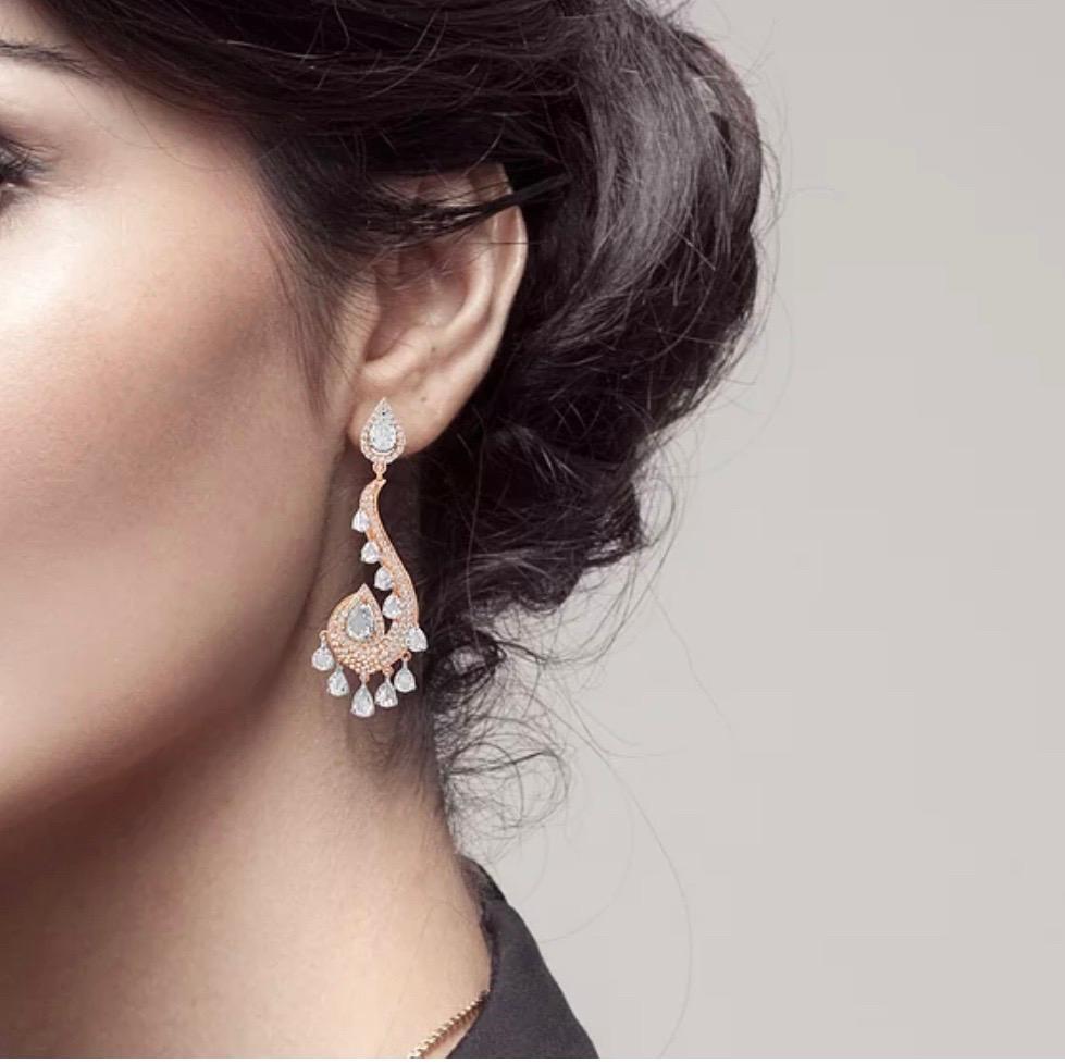 Entrez dans un monde d'enchantement avec ces exquises boucles d'oreilles pendantes de 6,92 carats de diamants ronds, brillants et taillés en rose, en or 18 carats. Ces boucles d'oreilles en or rose 18 carats, au motif cachemire oriental complexe,