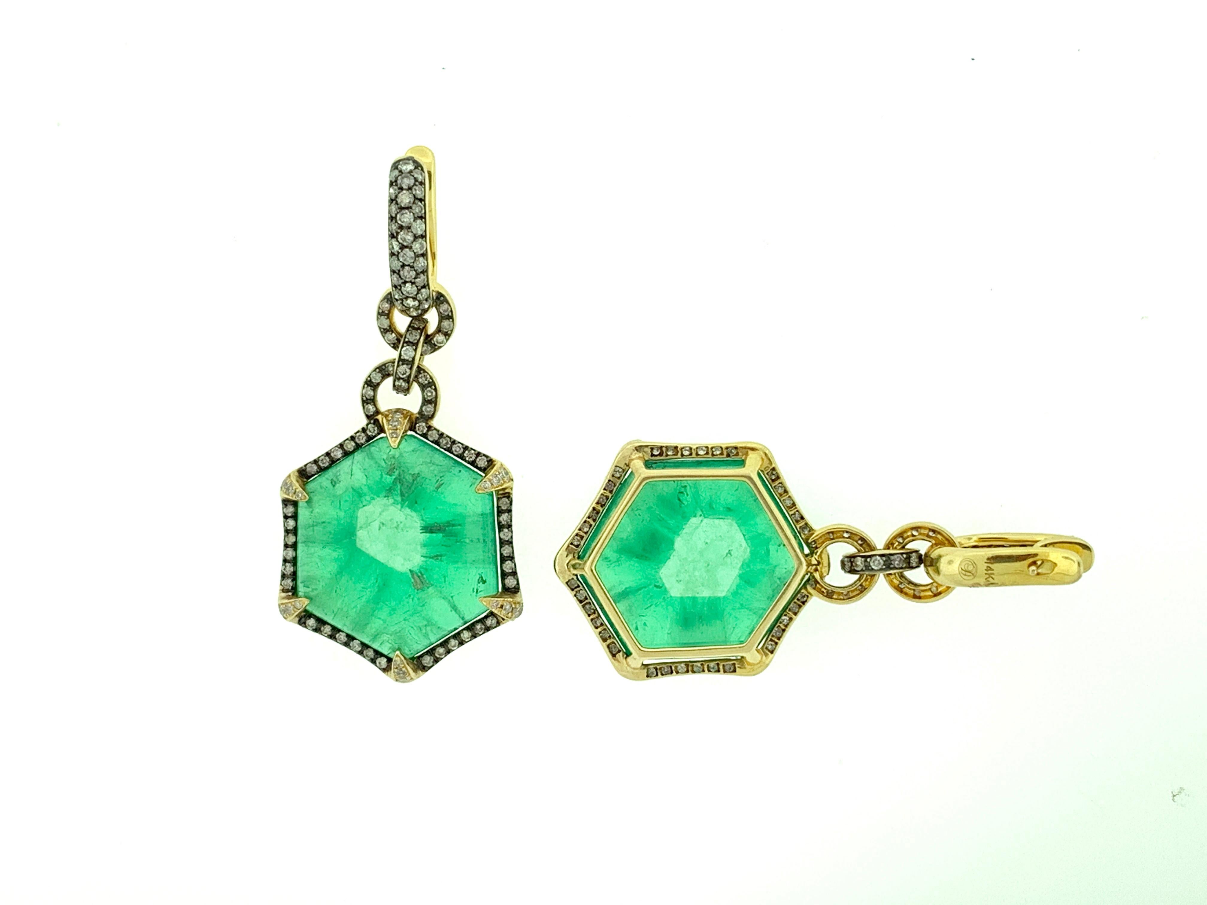 These stunning earrings feature 2 large and rare, hexagon cut, Colombian Trapiche Emeralds, weighing a total of 69.29 Carats. 
Each emerald is encircled in a single halo of round brilliant diamonds, hanging from a diamond hoop top. 
They are set in