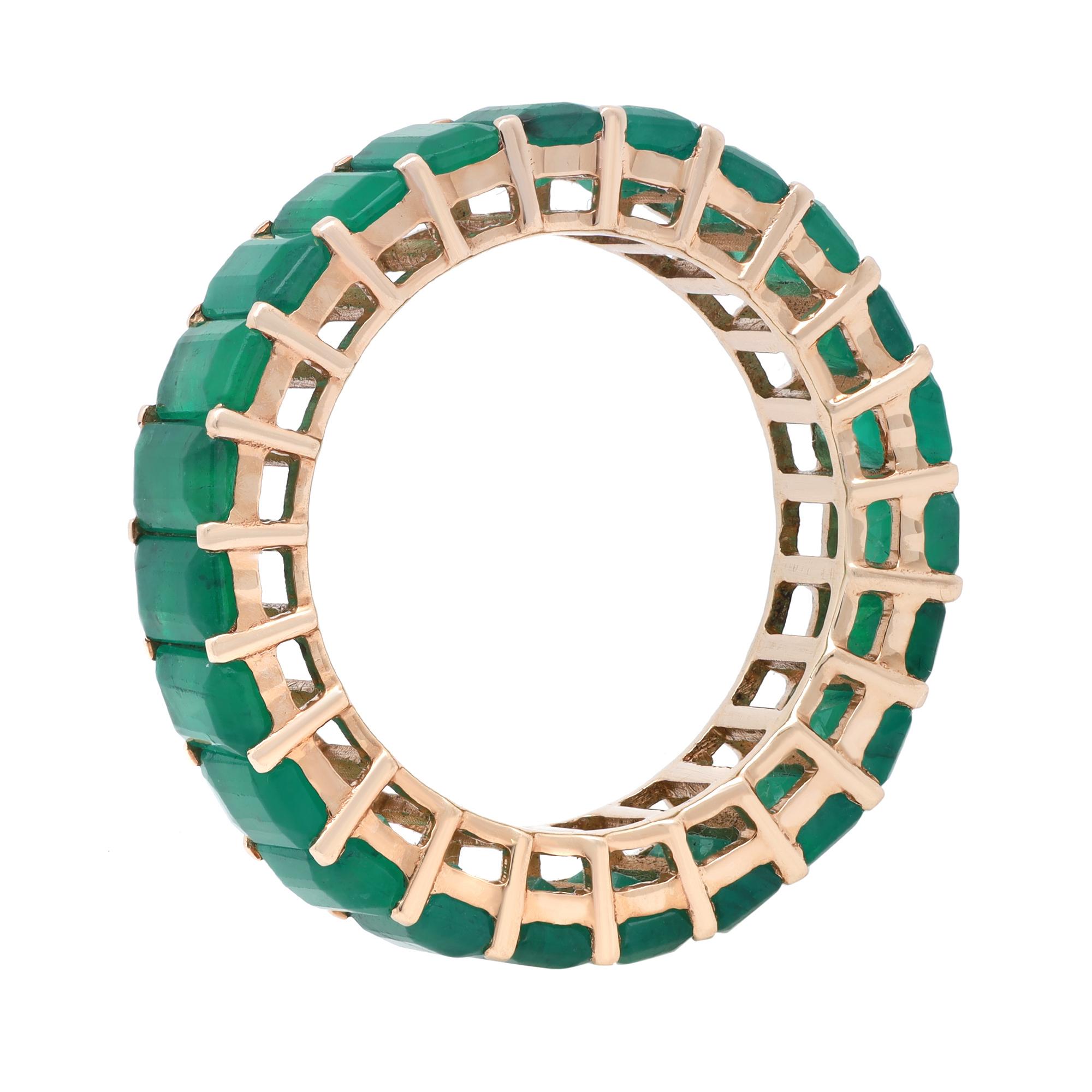 Stay classy with this stunning green Emerald eternity band ring. This exquisite ring is crafted in fine 14K yellow gold. It features 23 prong set Emerald cut Emeralds which weight 6.94 carats. Stackable and easy to mix and match. Ring size: 6.75.