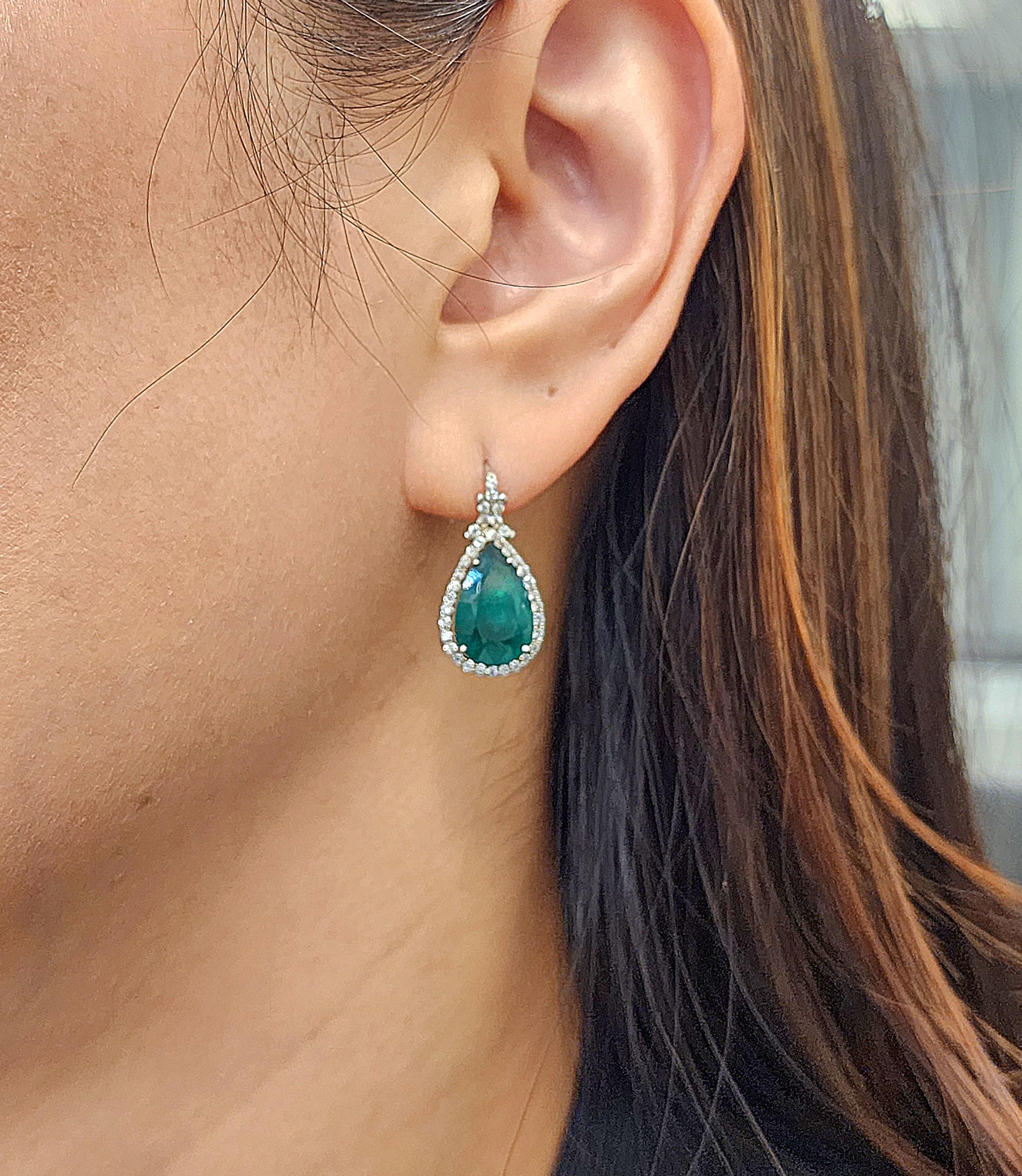 These beautiful emerald & diamond earrings feature 2 emeralds weighing 6.22 cts and diamonds weighing 0.74 cts set in 18k white gold.