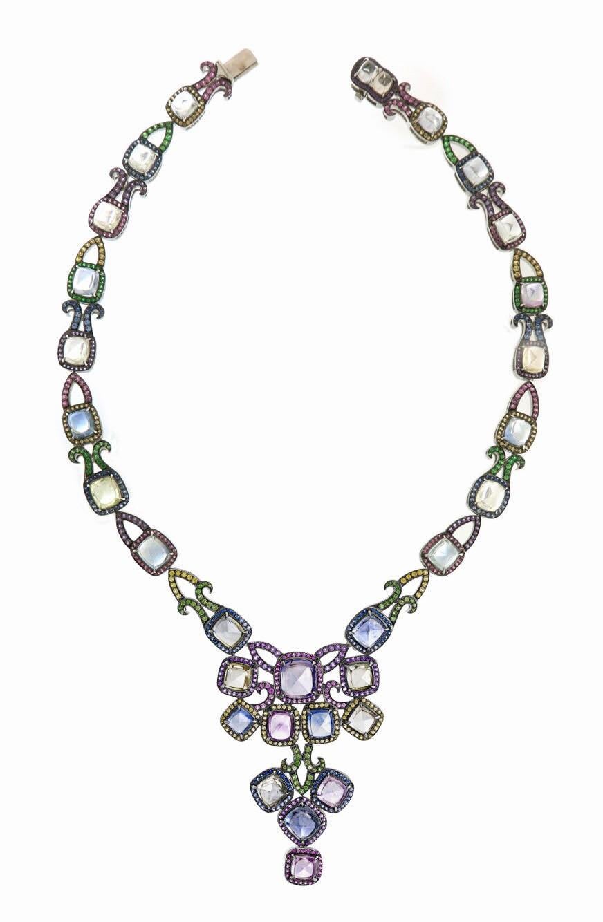 This rare and extraordinary Burmesese sugarloaf necklace is the star of a three piece set. These fancy sapphires are designed into a modern and sophicated design with our signature play on colour, set in 18k white gold. 69.19 carats of blue sapphire