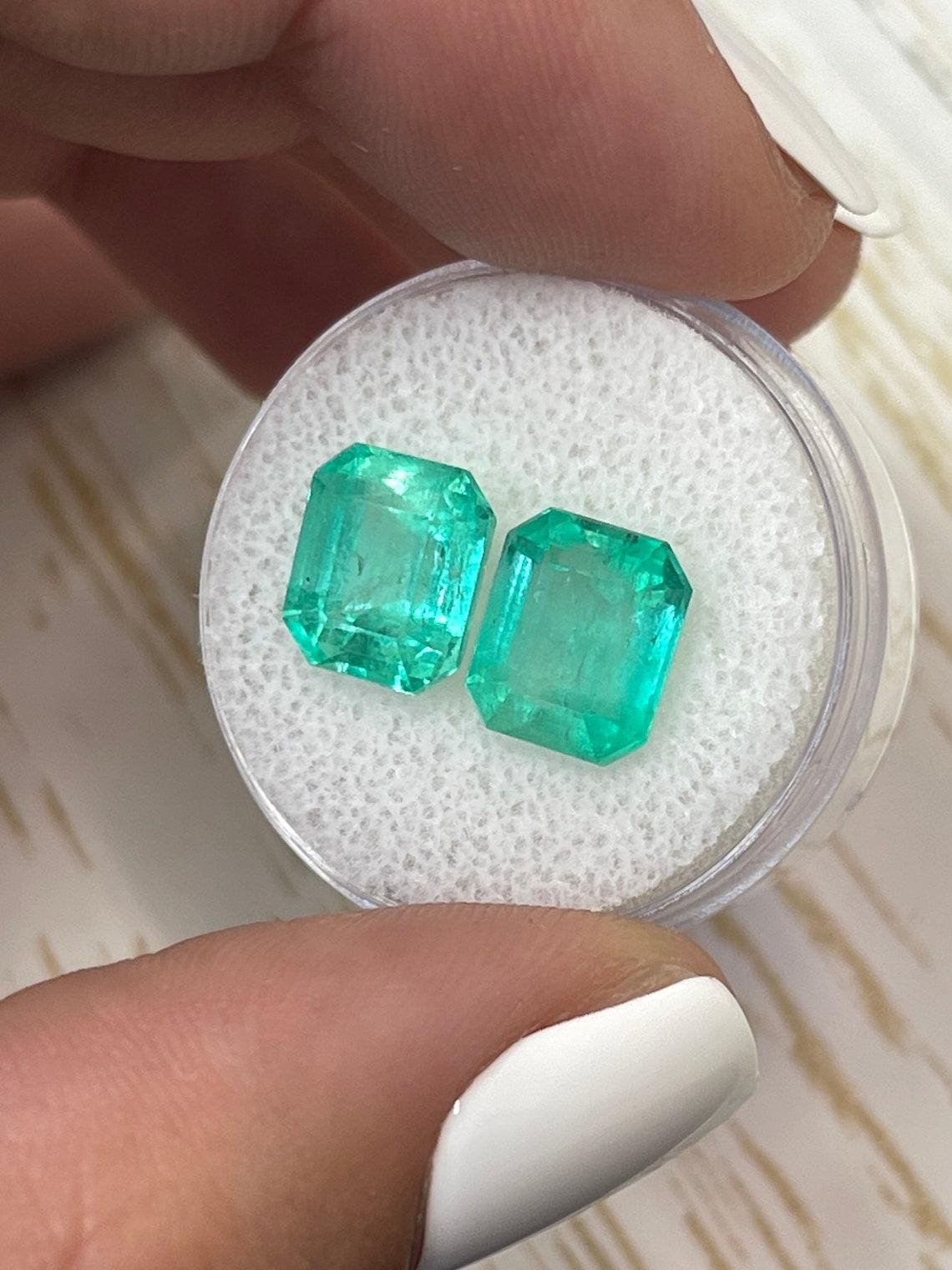Stone: Emerald
Total Weight: 6.96-tcw
Shape: Emerald Cut
Clarity: Transparent
Luster: Very Good
Color: Medium Bluish Green
Measurements: 9.50mm x 8.03mm x 6.53mm // 9.48mm x 8.01mm x 5.78mm
Geographic Origin: Colombia
Treatment: Natural, Moderate