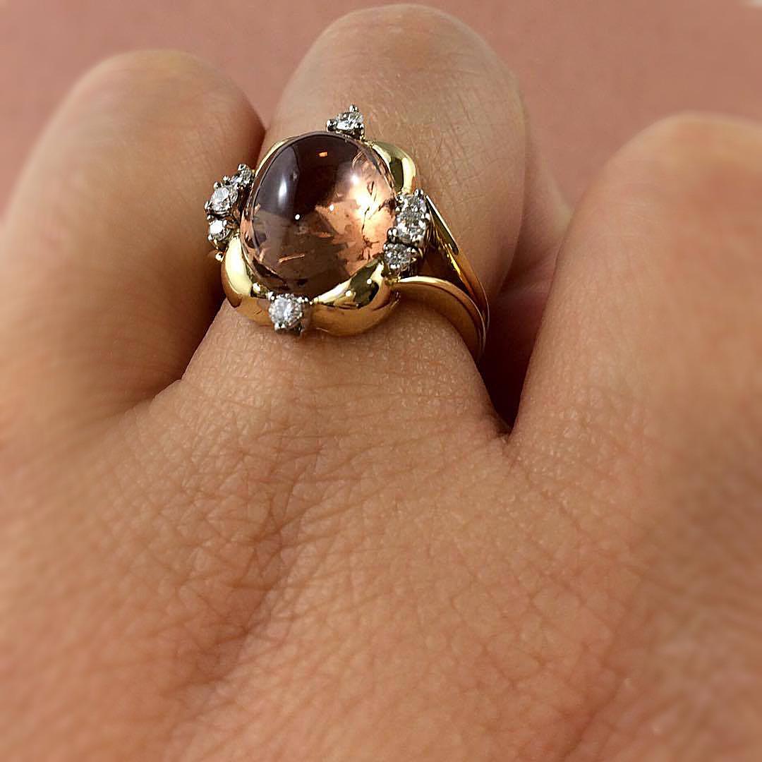 A really elegant and understated handmade cocktail ring with the beauty of the oval brown tourmaline cabochon being simply enhanced by a few round brilliant diamonds placed around it.  The tourmaline weighs 6.98 carat and the total diamond weight is