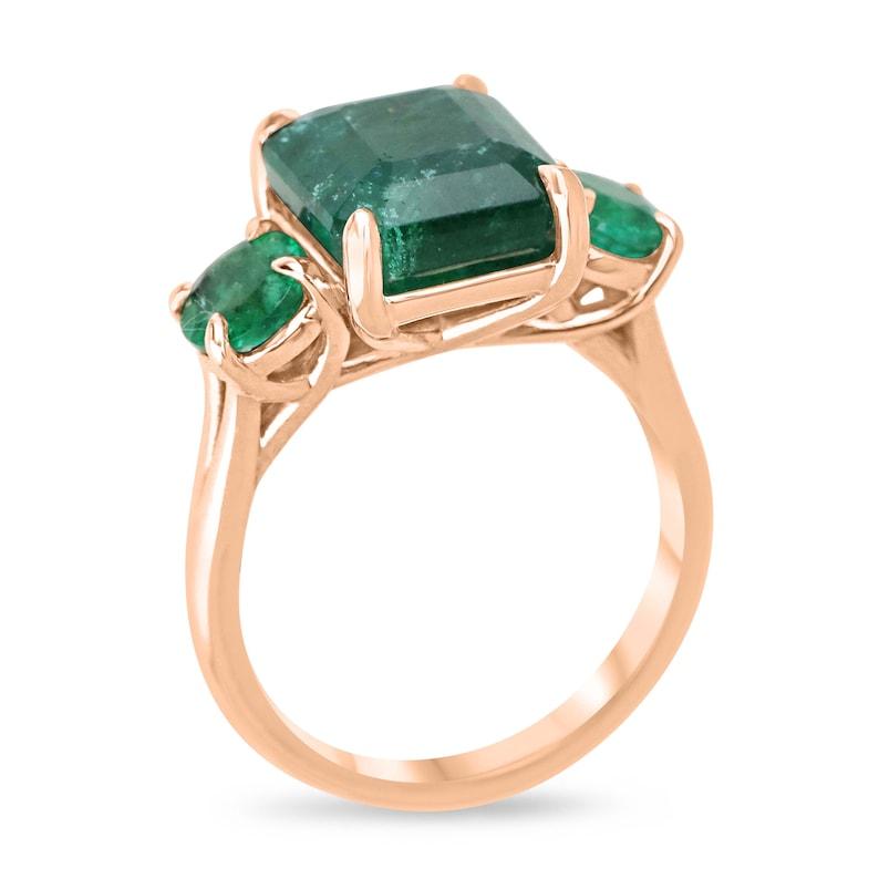 Adorn yourself with the timeless beauty of our emerald three-stone trilogy ring, featuring a magnificent 5.70 carat emerald-cut center stone flanked by round-cut emeralds. Each gemstone, sourced from Zambia, radiates a deep, rich green color with