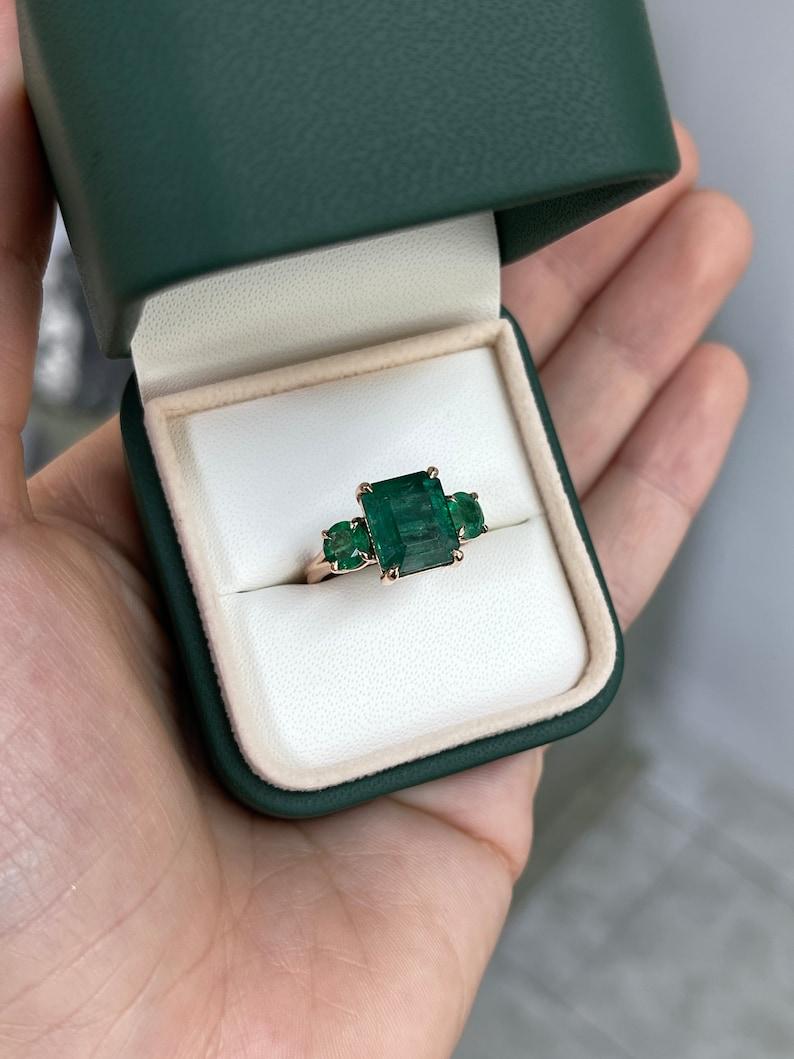 Round Cut 6.98tcw 14K Emerald Cut & Round Emerald Trilogy Ring - Deep Green 585 Rose Gold For Sale
