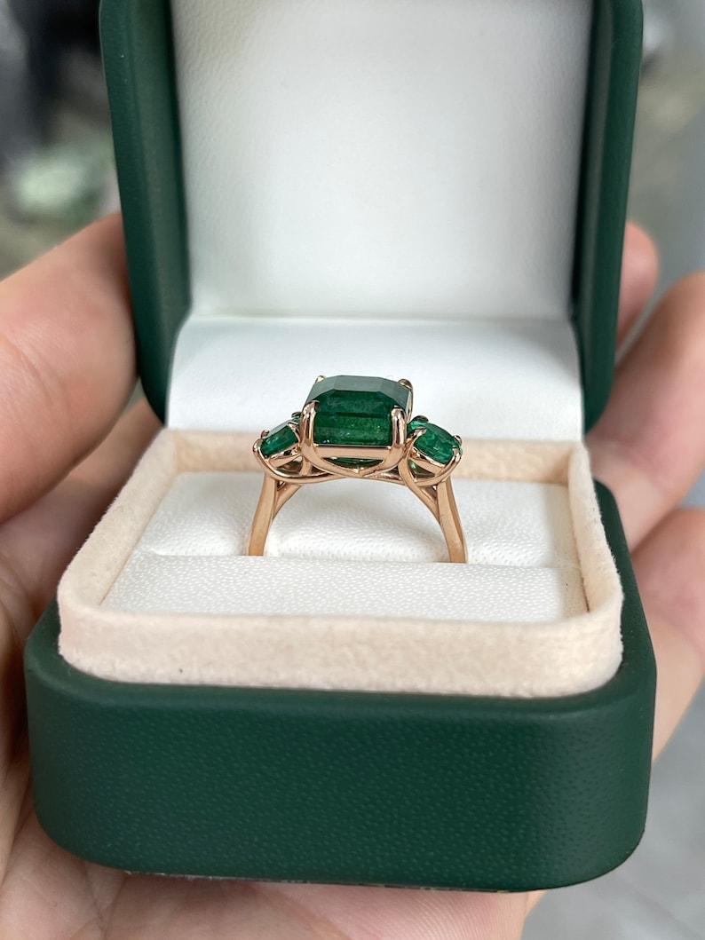 Women's 6.98tcw 14K Emerald Cut & Round Emerald Trilogy Ring - Deep Green 585 Rose Gold For Sale