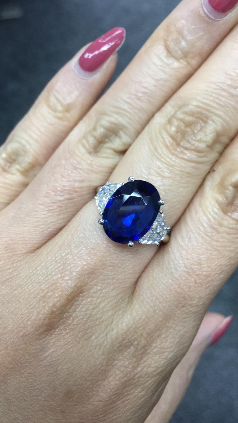 Primary Stone: Sapphire ( Burma-Myanmar )
Shape : Oval Cut
Sapphire Weight: 6.99 Carats 
Measurements Sapphire: 13.30mm x 9.72mm x 4.71mm
Color: Royal Blue
Accent Stones: Genuine Diamond
Shape Or Cut Diamond: 2 Triangular Brilliants
Average