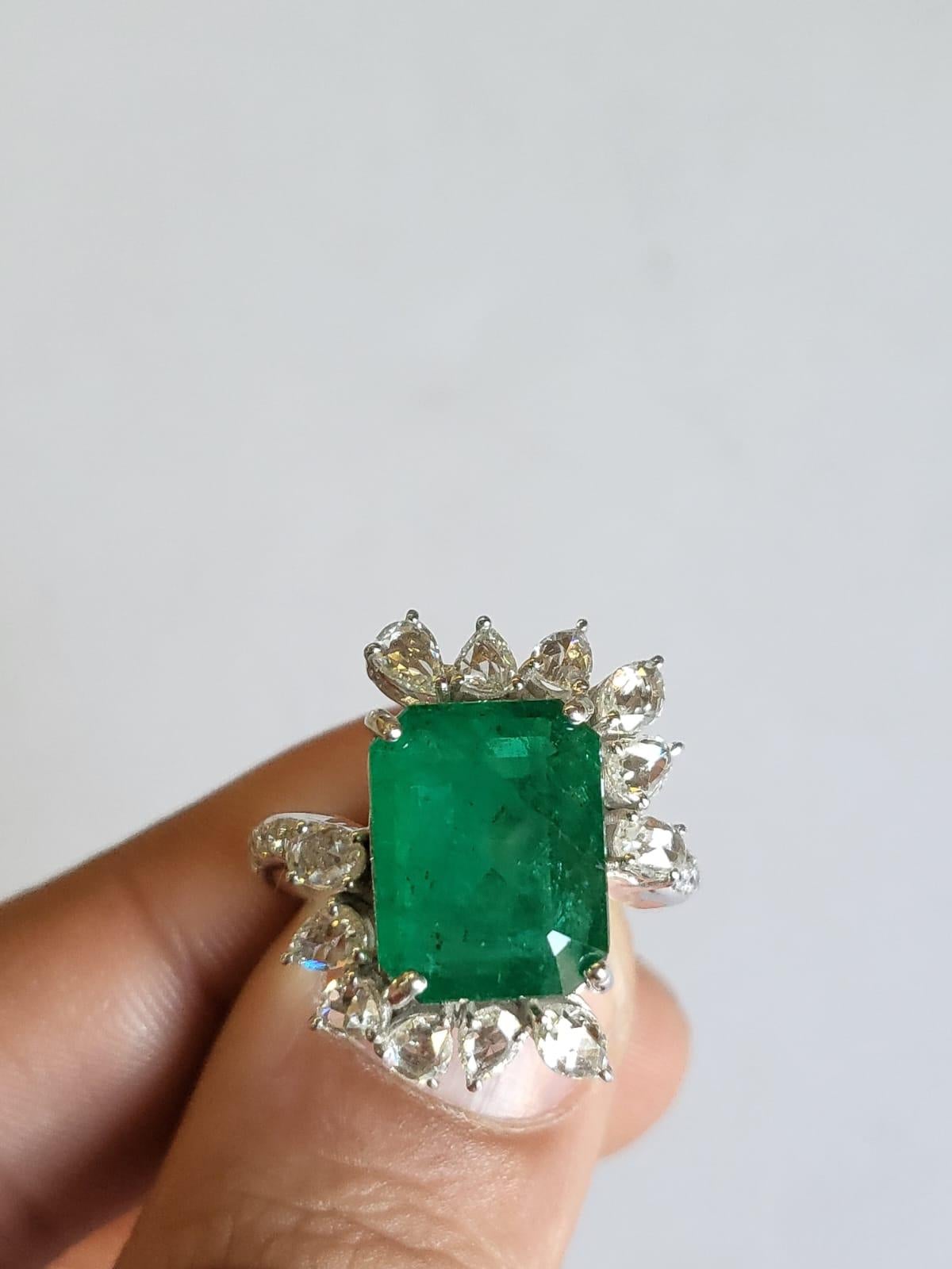 A very gorgeous and one of a kind, Emerald Cocktail / Engagement Ring set in 18K White Gold & Diamonds. The weight of the Emerald is 6.99 carats. The Emerald is completely natural, without any treatment & is of Zambian origin. The combined weight of