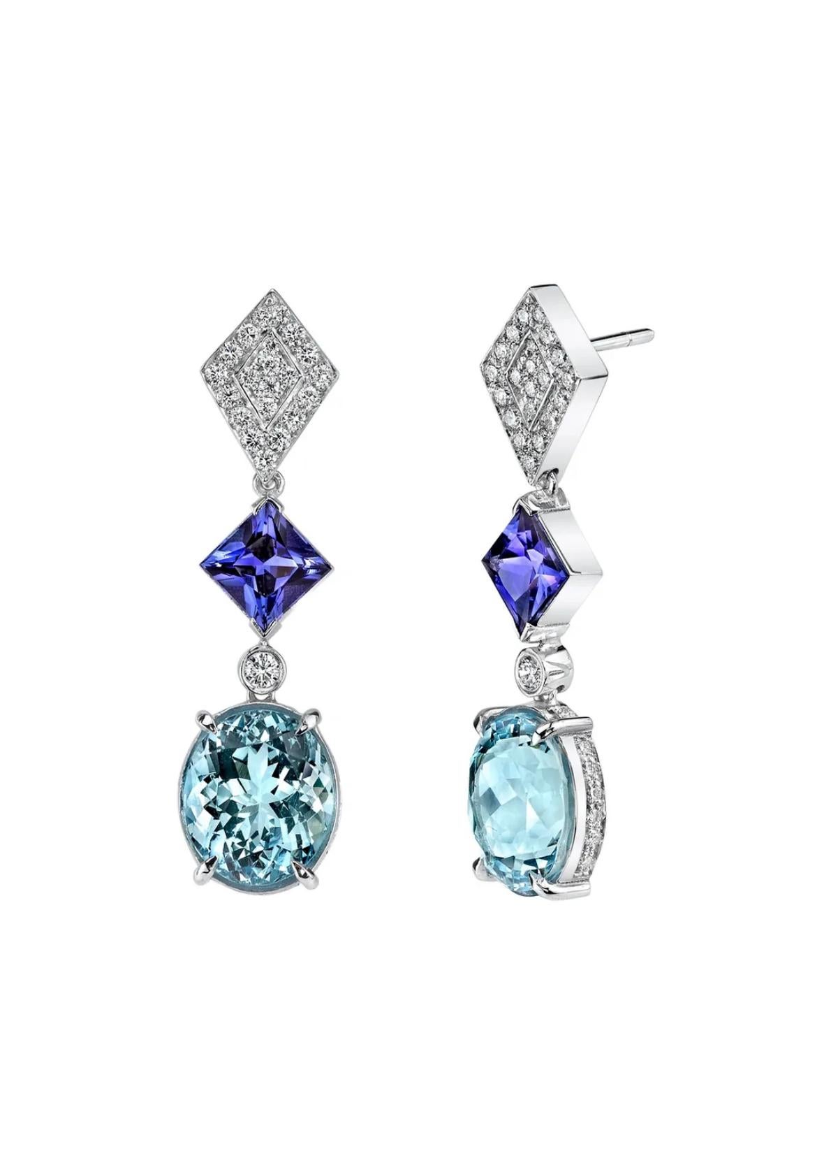 A exquisite pair of oval-cut Aquamarines, totaling 6.99 carats are the stars of these exuberant 18K white gold earrings. Joining the Aquamarines are two ravishing Tanzanites totaling 2.65 carats, encircled by numerous shimmering diamonds weighing a