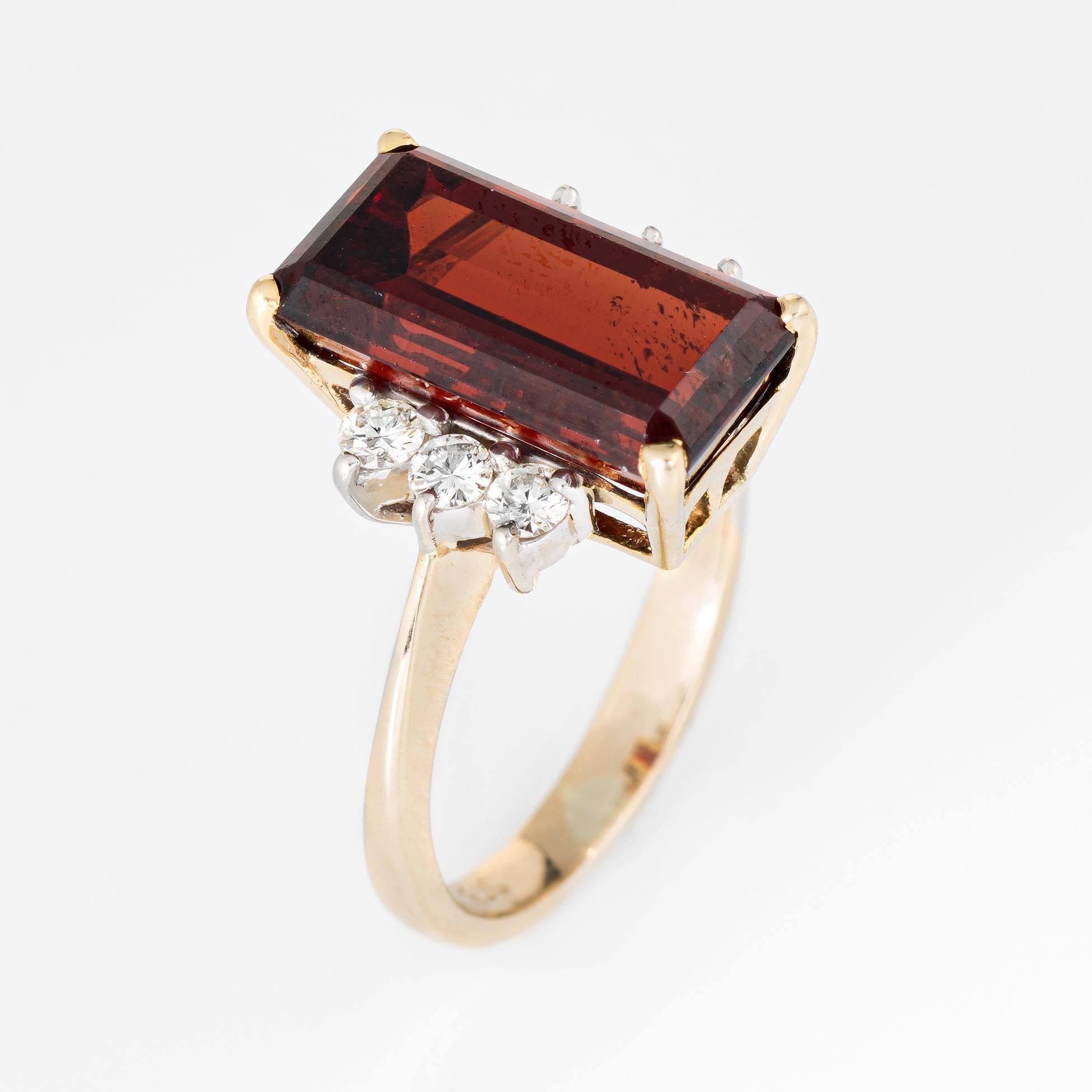 Stylish vintage cherry garnet & diamond cocktail ring (circa 1970s to 1980s) crafted in 14 karat yellow gold. 

Emerald cut cherry garnet measures 14mm x 7.5mm (estimated at 6 carats) is accented with six estimated 0.04 carat diamonds. The total