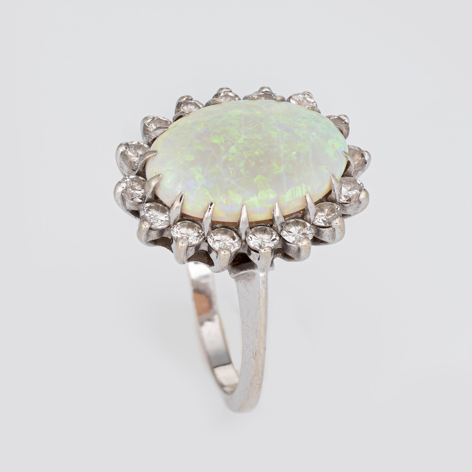 Stylish vintage natural opal & diamond ring (circa 1950s to 1960s) crafted in 14 karat white gold. 

Natural opal measures 15mm x 10mm (estimated at 6 carats). 16 round brilliant cut diamonds are estimated at 0.05 carats each and total an estimated