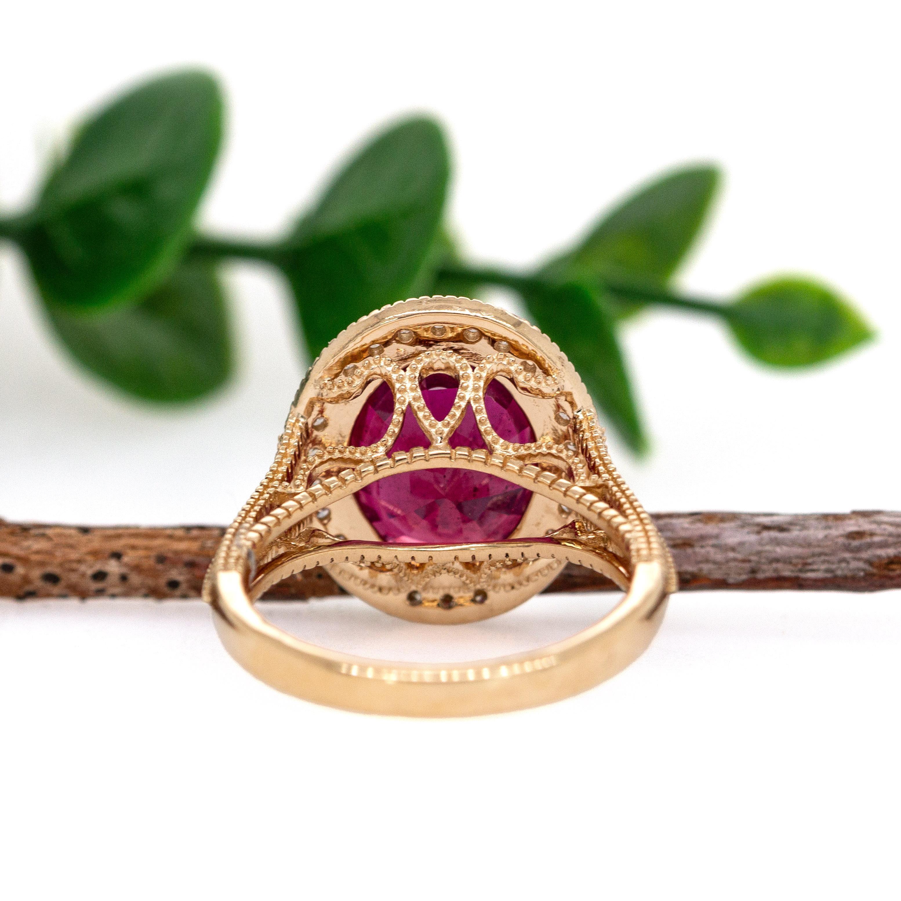 Cette bague exquise met en valeur un rubis de Madagascar de forme ovale de 5,9ct, mesurant 12x10mm, connu pour sa riche teinte rouge. Serti dans 4,71 g d'or 14k, le rubis est magnifiquement mis en valeur par 30 diamants totalisant 0,37cttw. Un