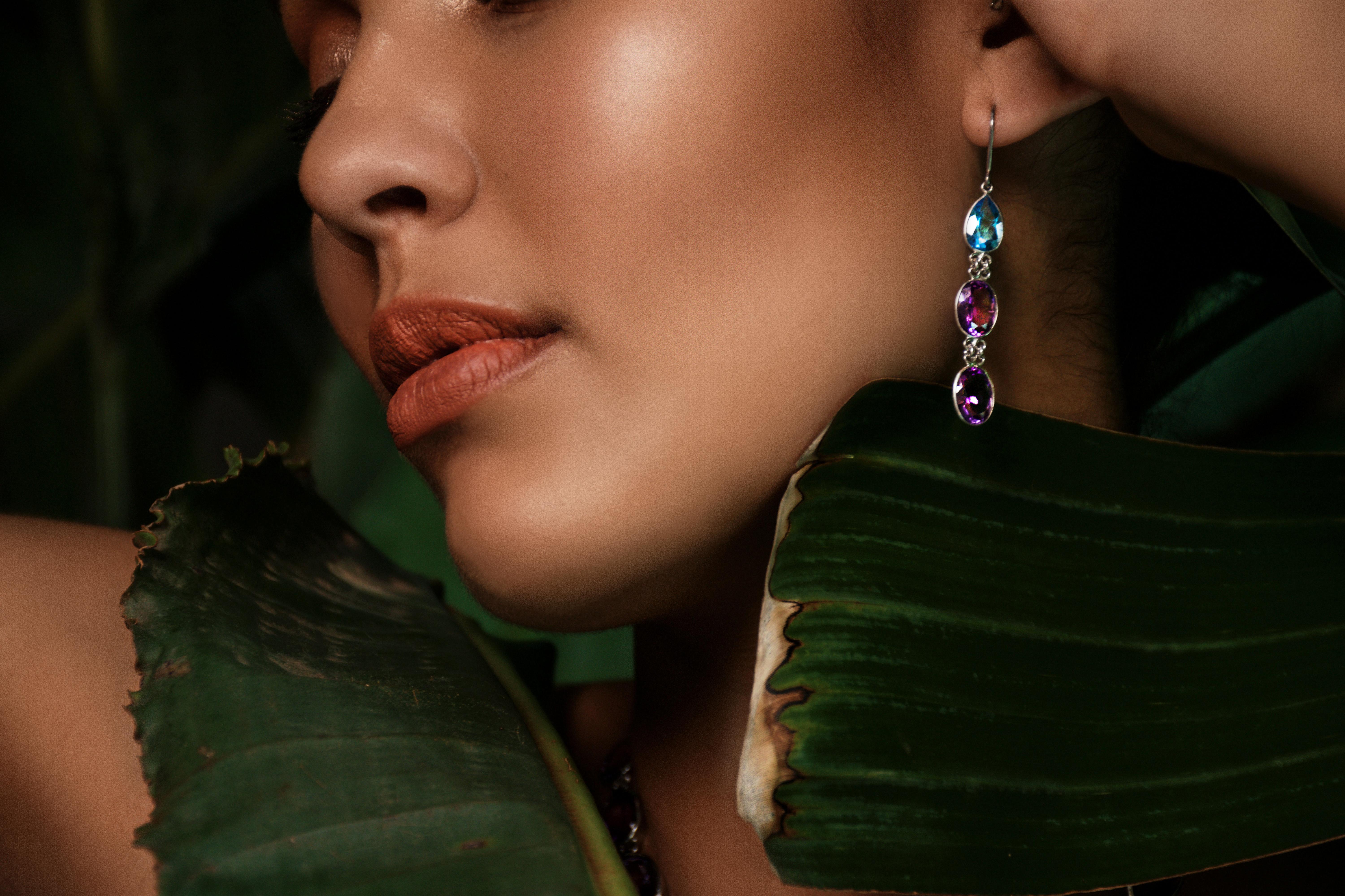 Introducing our Topaz & Amethyst Gemstone Link Drop Earrings of platinum coated sterling silver, a stunning fusion of two exquisite gemstones that epitomize elegance and allure. Each earring features a 2-carat pear-cut topaz gemstone at the top,