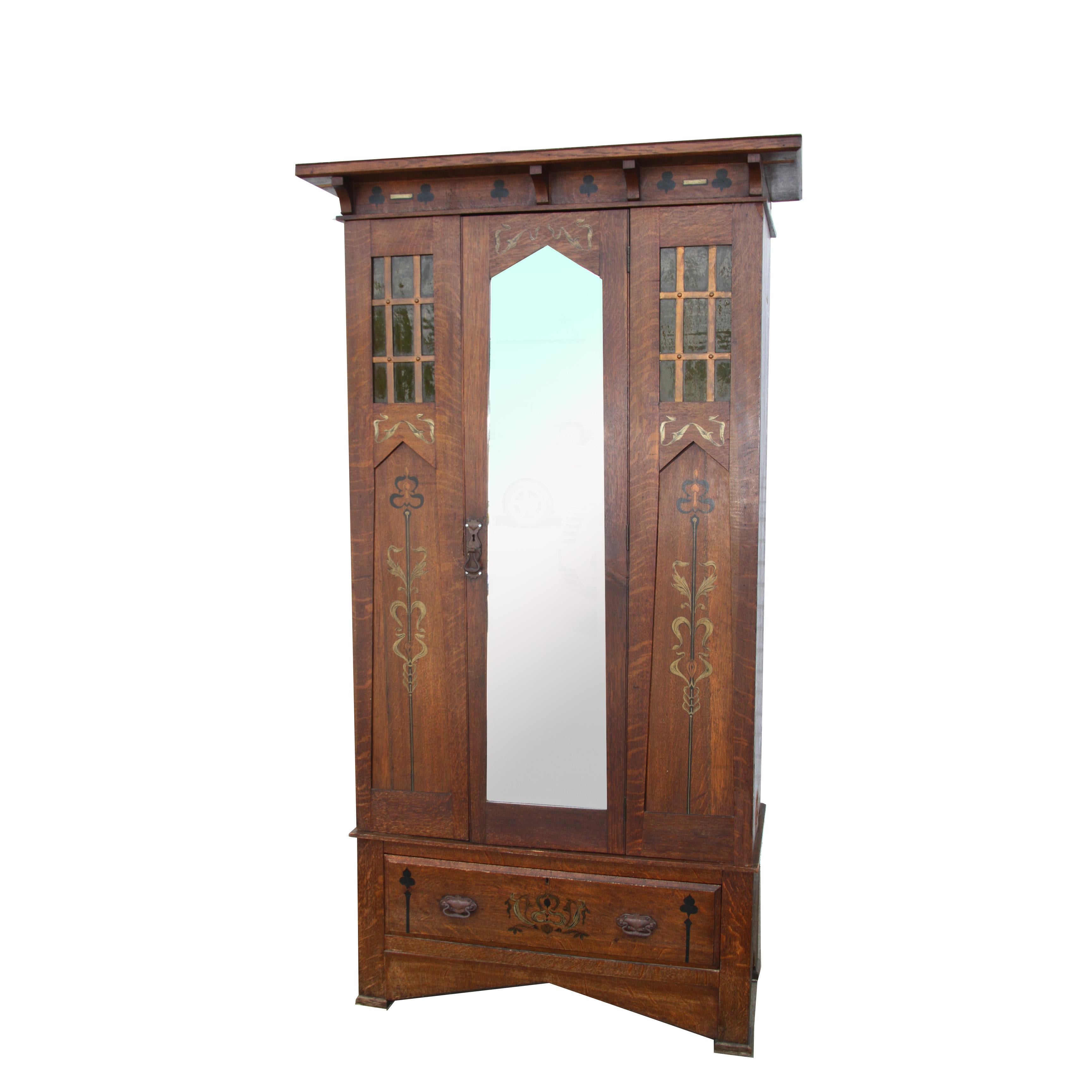 6FT Arts and Crafts Mission Oak Armoire

Arts and Crafts oak wardrobe with top cornice, decorative windows and a full-length original beveled mirror door. Opens to a full-length hanging space inside with a large deep drawer below. Floral inlays.