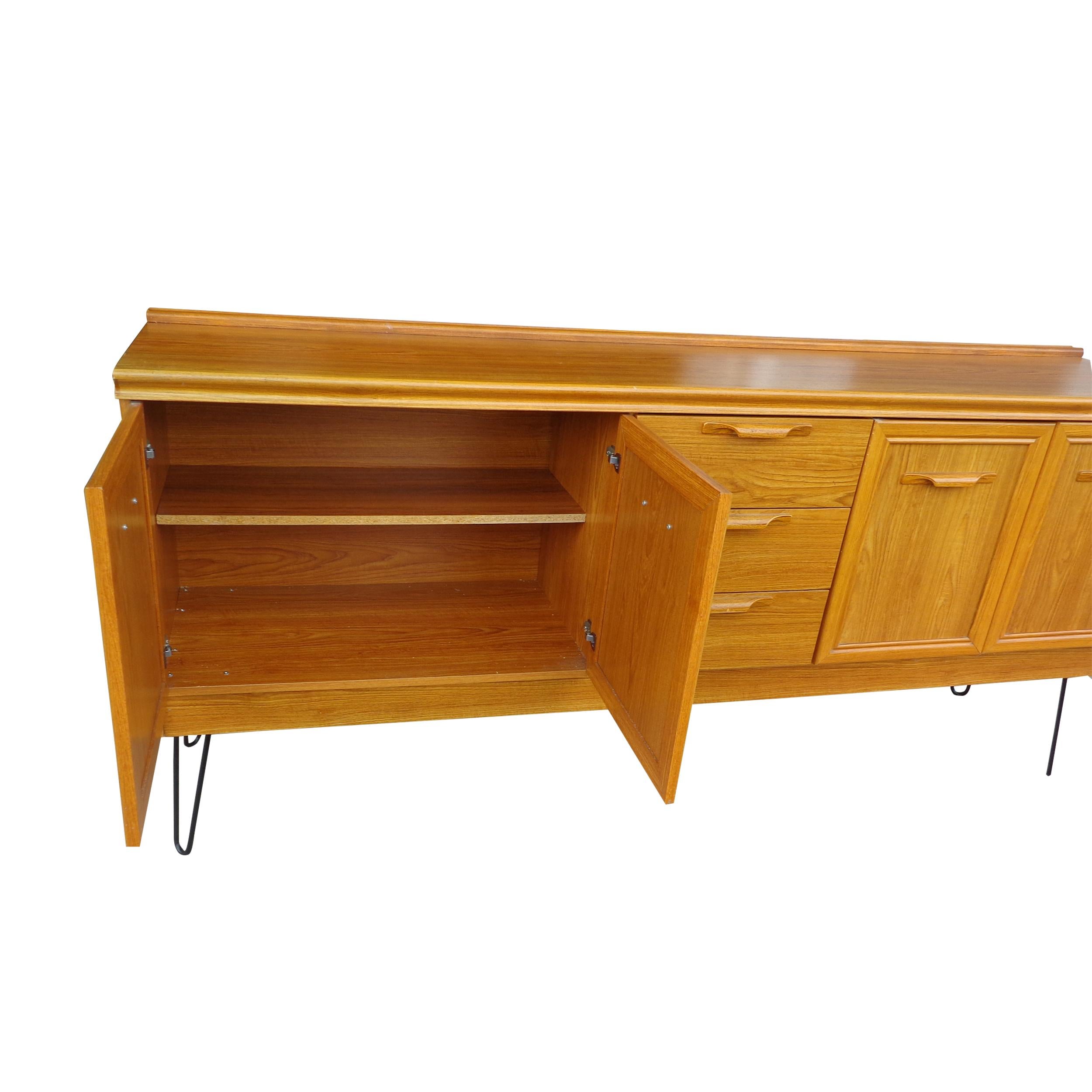 6ft Mid-Century Modern oak sideboard with hair pin legs by Jentique

This oak sideboard features a spacious double cupboard and three drawers. Sculptural folded handles. Updated with hairpin legs in black.

