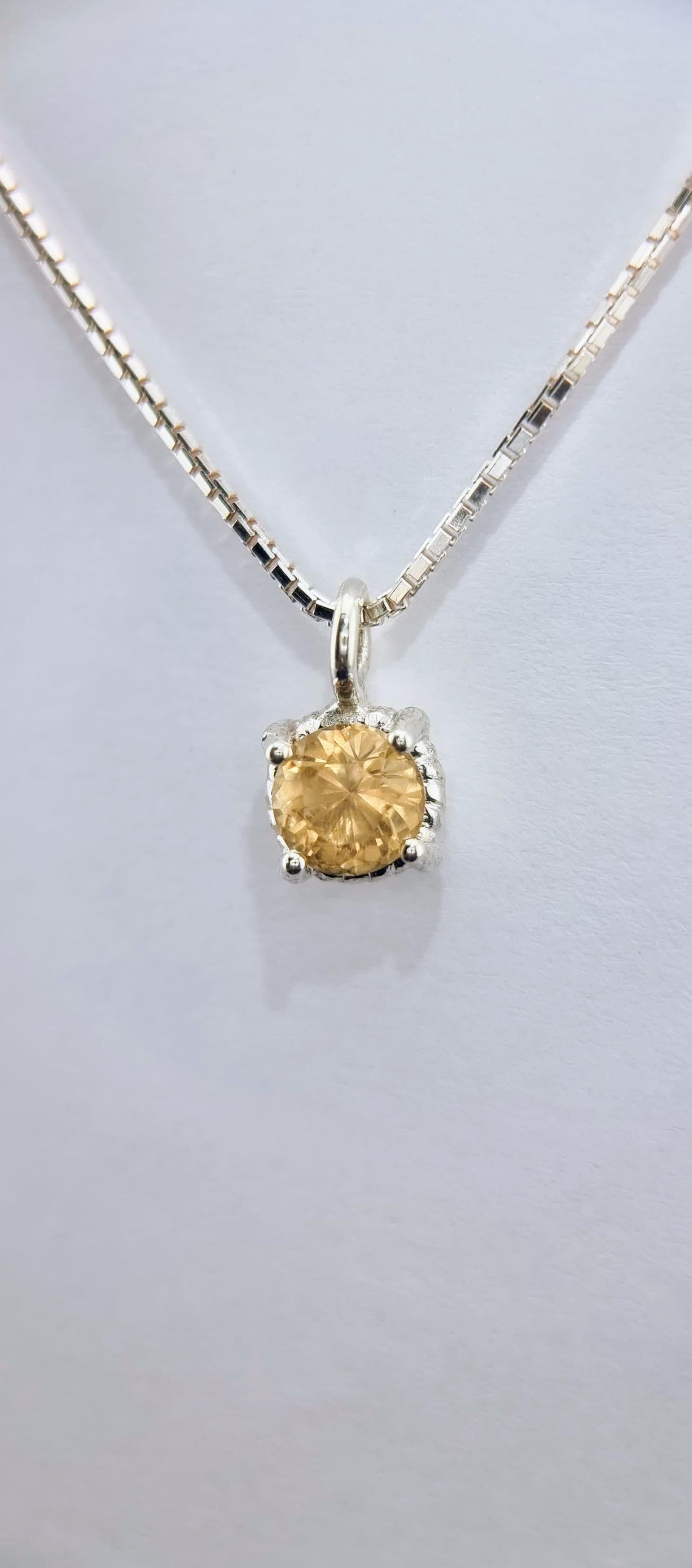 Irradiant de chaleur et de brillance, ce pendentif en citrine délicate présente une citrine naturelle ronde de 6 mm de diamètre sertie dans un design raffiné à quatre branches torsadées. Célébrée comme la pierre de l'abondance et de la joie, la