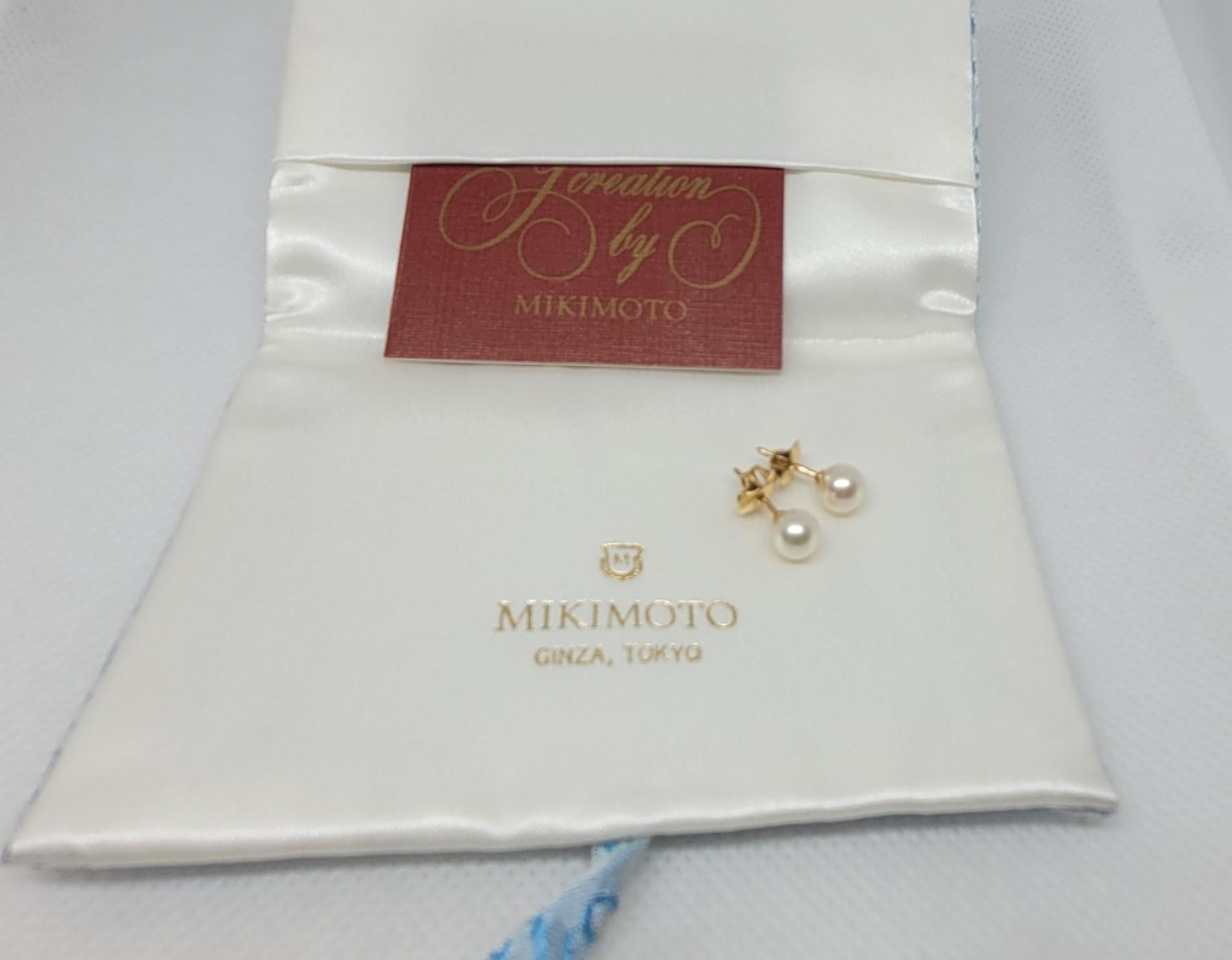14kt yellow gold 6mm round white cultured pearl studs with friction post by Mikimoto, with original Mikimoto pouch. The earrings weigh 1.3 grams in total, are stamped 14kt, and feature the 