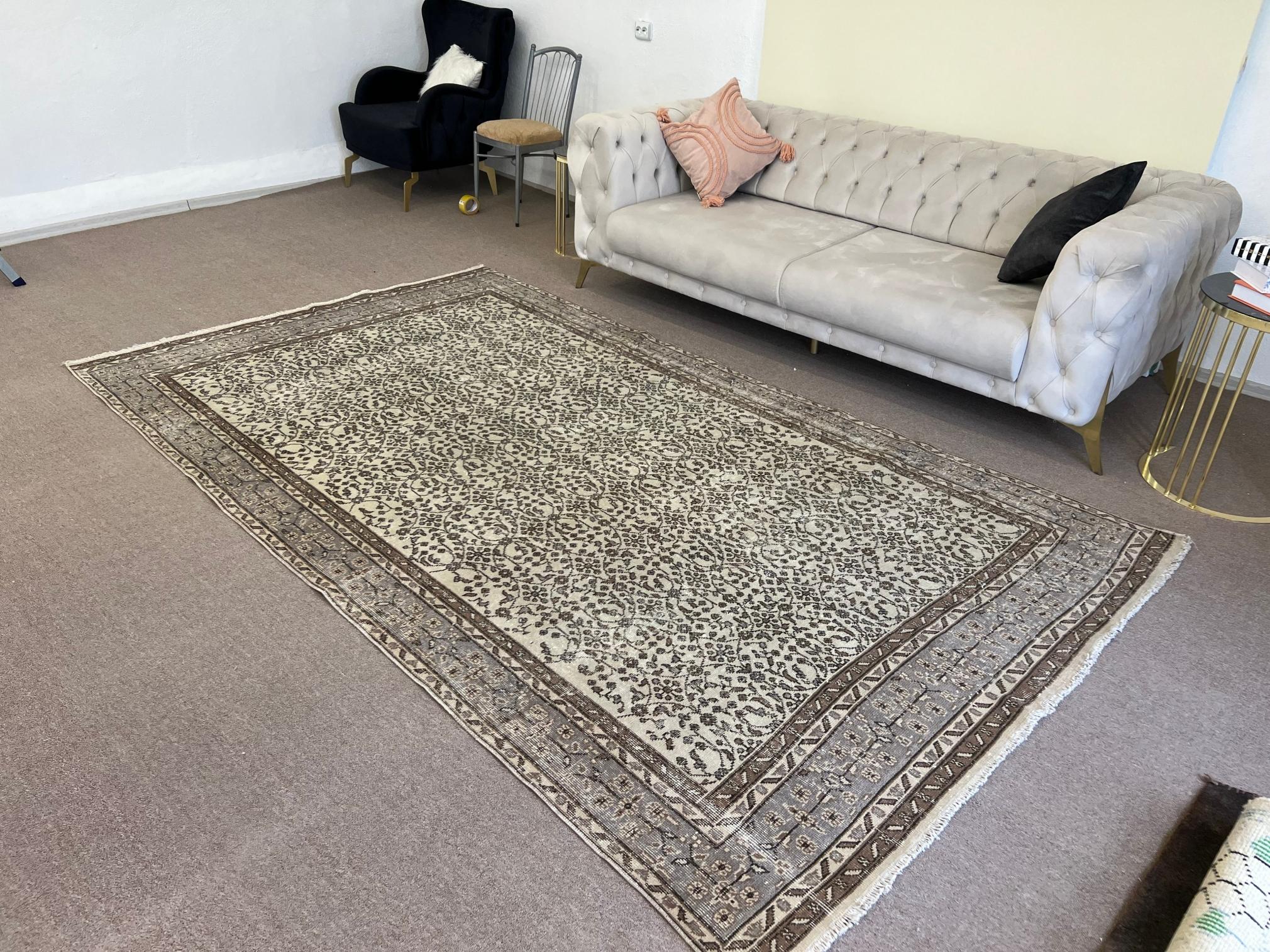 Una alfombra turca vintage de colores beige y marrón. Se anudó a mano en los años sesenta y tiene un diseño floral integral. Bajo pelo de lana sobre base de algodón finamente tejido. Resistente y puede utilizarse en una zona de mucho tráfico,
