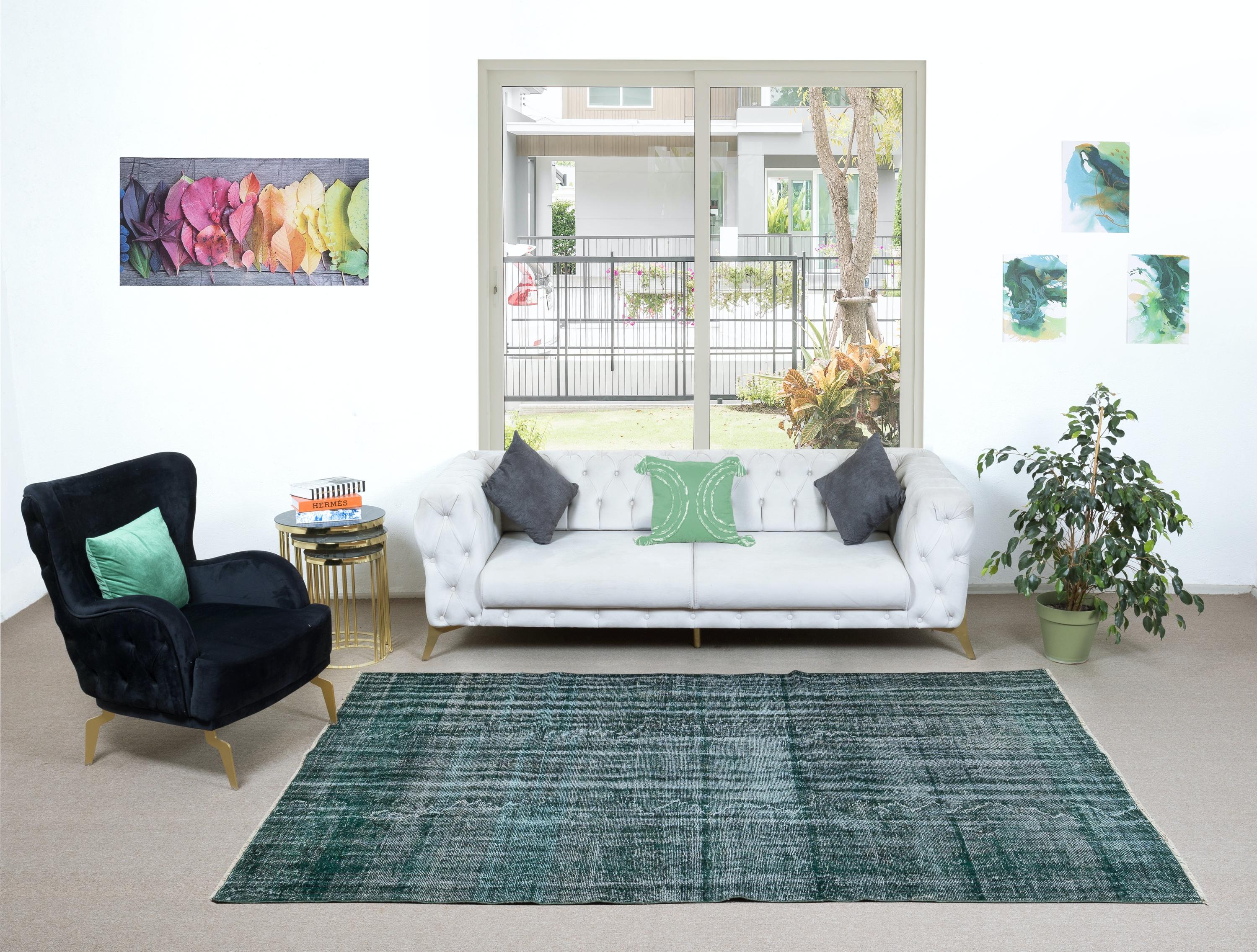 A vintage Turkish area rug re-dyed in green color for contemporary interiors. Measures: 6.3 x 9.5 Ft
Finely hand knotted, low wool pile on cotton foundation. Professionally washed.
Sturdy and can be used on a high traffic area, suitable for both