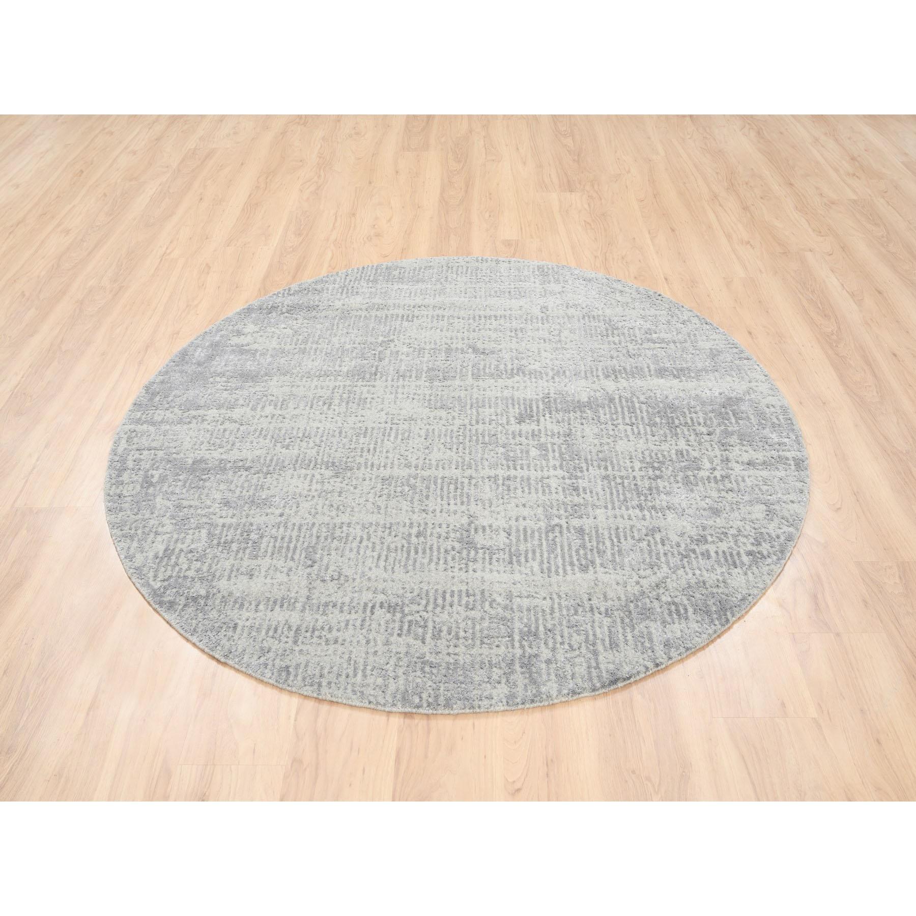 Il s'agit d'un véritable tapis rond oriental ton sur ton en laine et soie d'origine végétale, tissé à la main en jacquard gris de style moderne. Il a été tissé pendant des mois et des mois selon des techniques artisanales séculaires par des artisans