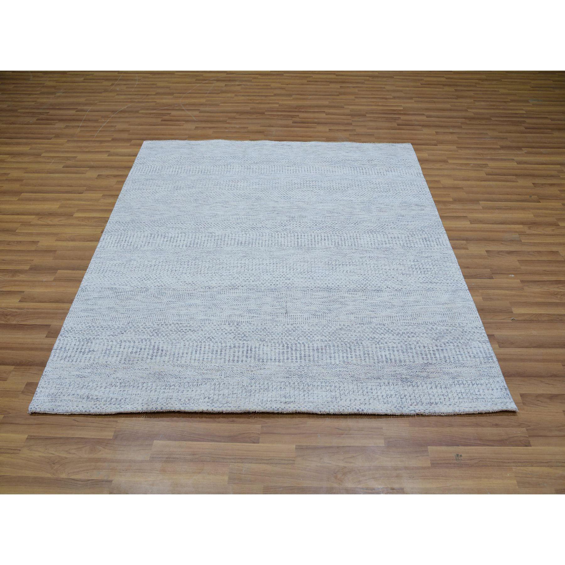 Il s'agit d'un véritable tapis d'Orient en pure laine non teintée, ton sur ton, au design moderne de graminées, noué à la main. Il a été noué pendant des mois et des mois par des artisans selon des techniques de tissage séculaires.
Matières