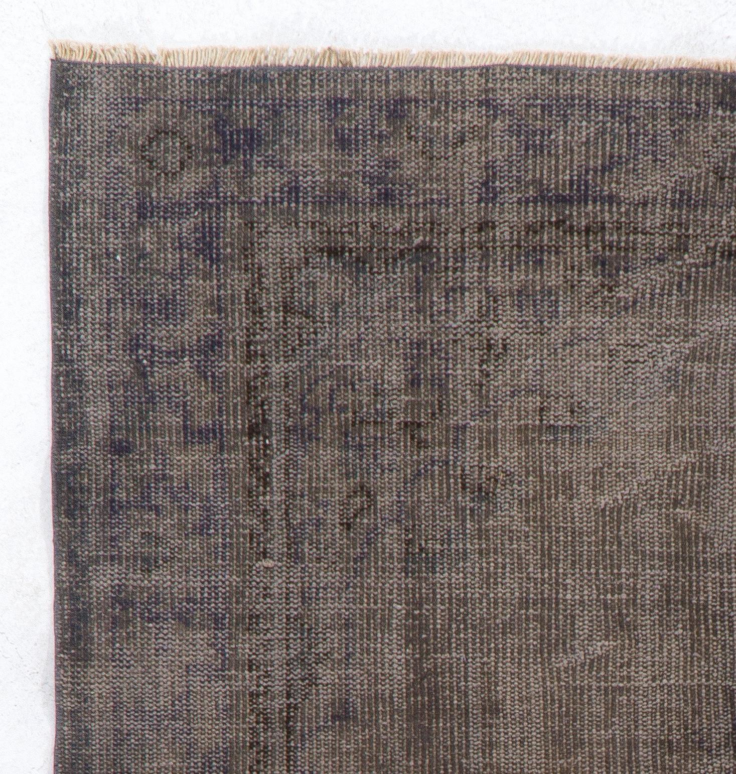 A vintage Turkish area rug over-dyed in gray. It is finely hand-knotted and has distressed low wool pile on cotton foundation. It is deep-washed, in good condition, sturdy and can be used in areas with high foot traffic. Suitable for both
