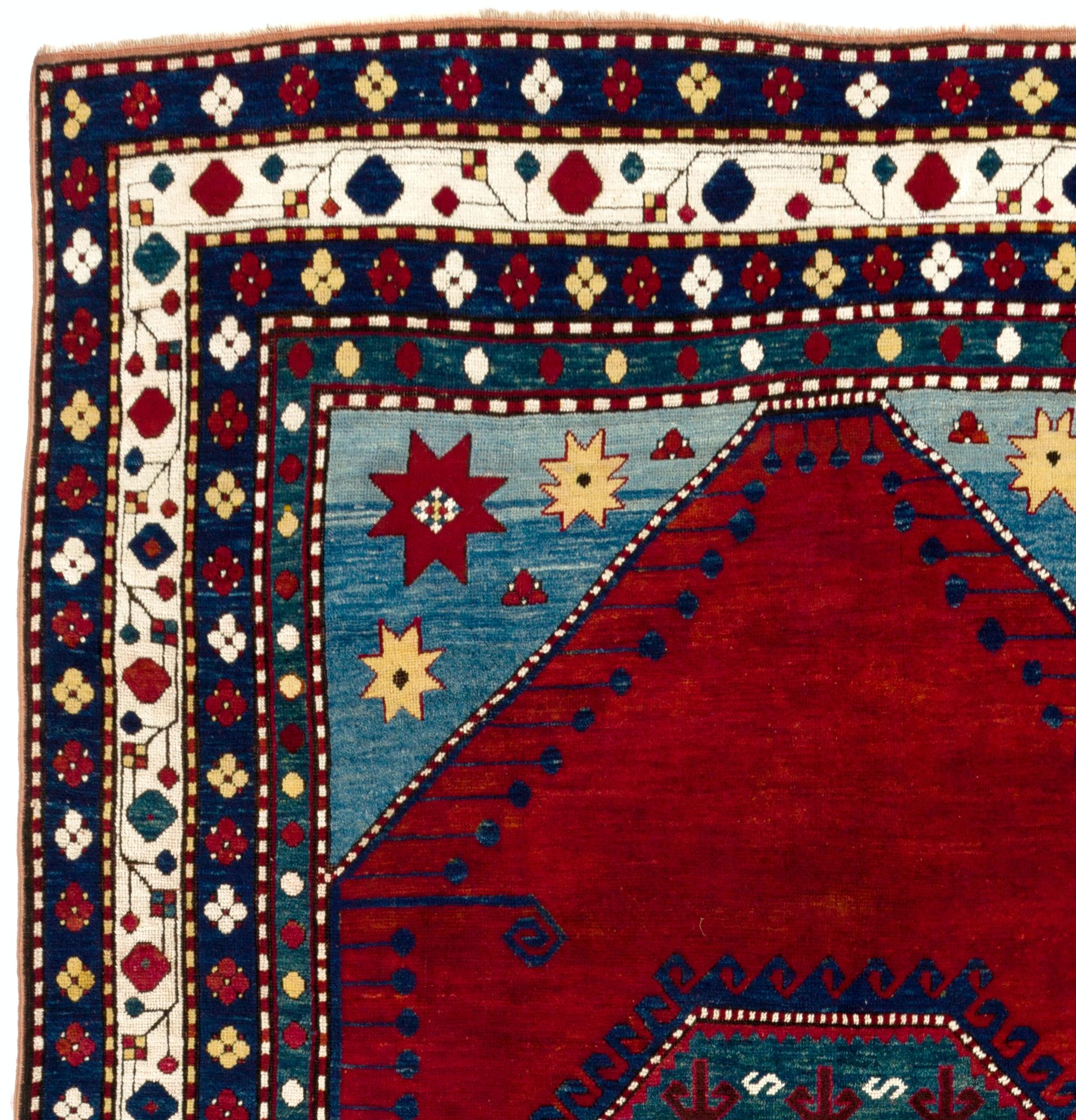 This exquisite South Caucasian Kazak rug features a central medallion rendered in a serene dark sea green layered with contrasting tones of madder and white in the form of motifs such as ram's horns, dragons and hooks set against a very vivid and