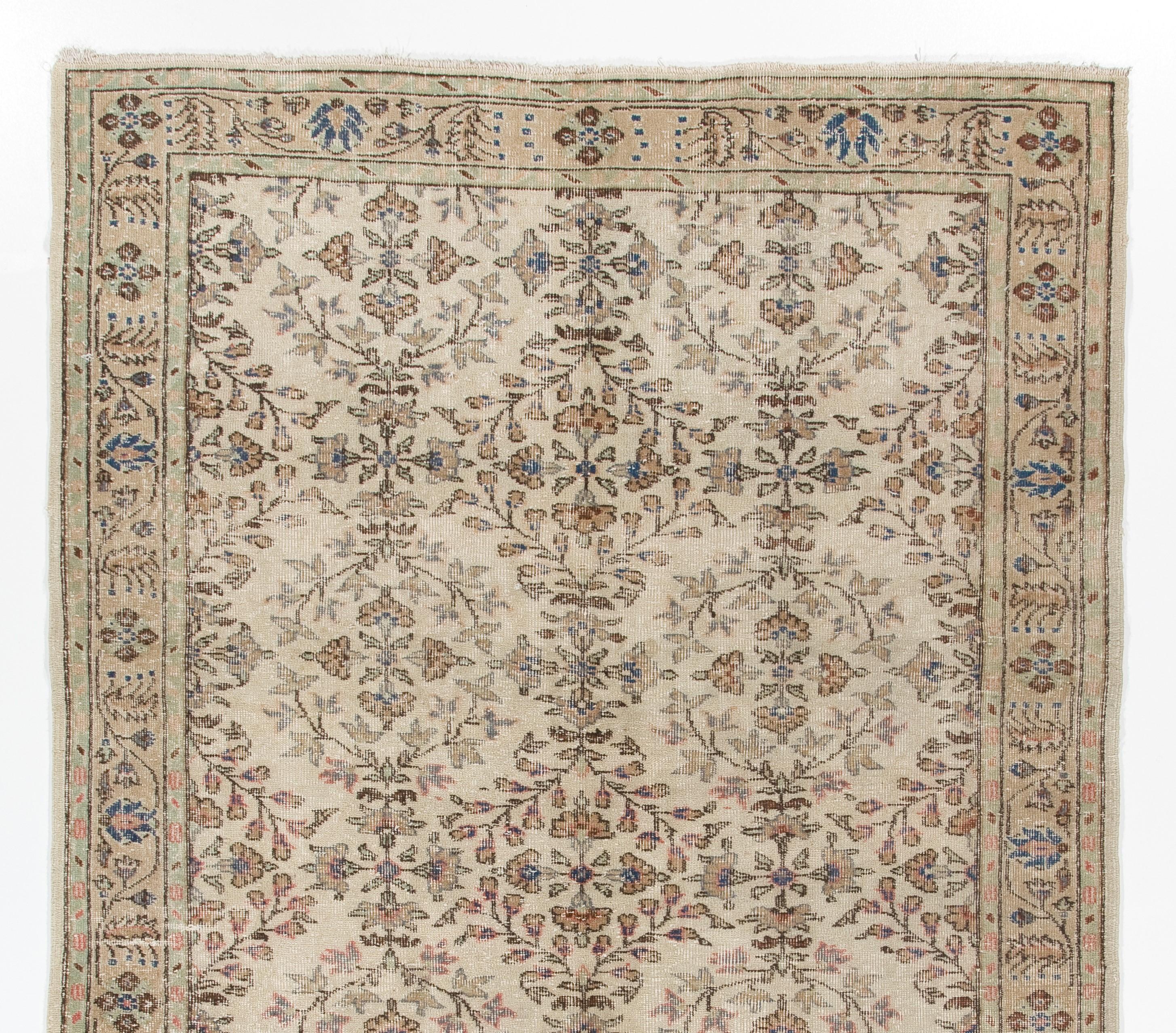 This vintage hand knotted Turkish Oushak area rug was made in the 1960s. It has low wool pile on cotton foundation. It is sturdy, in good condition and very clean. It features elegant floral heads in quatrefoil form in gently swirling lattices of