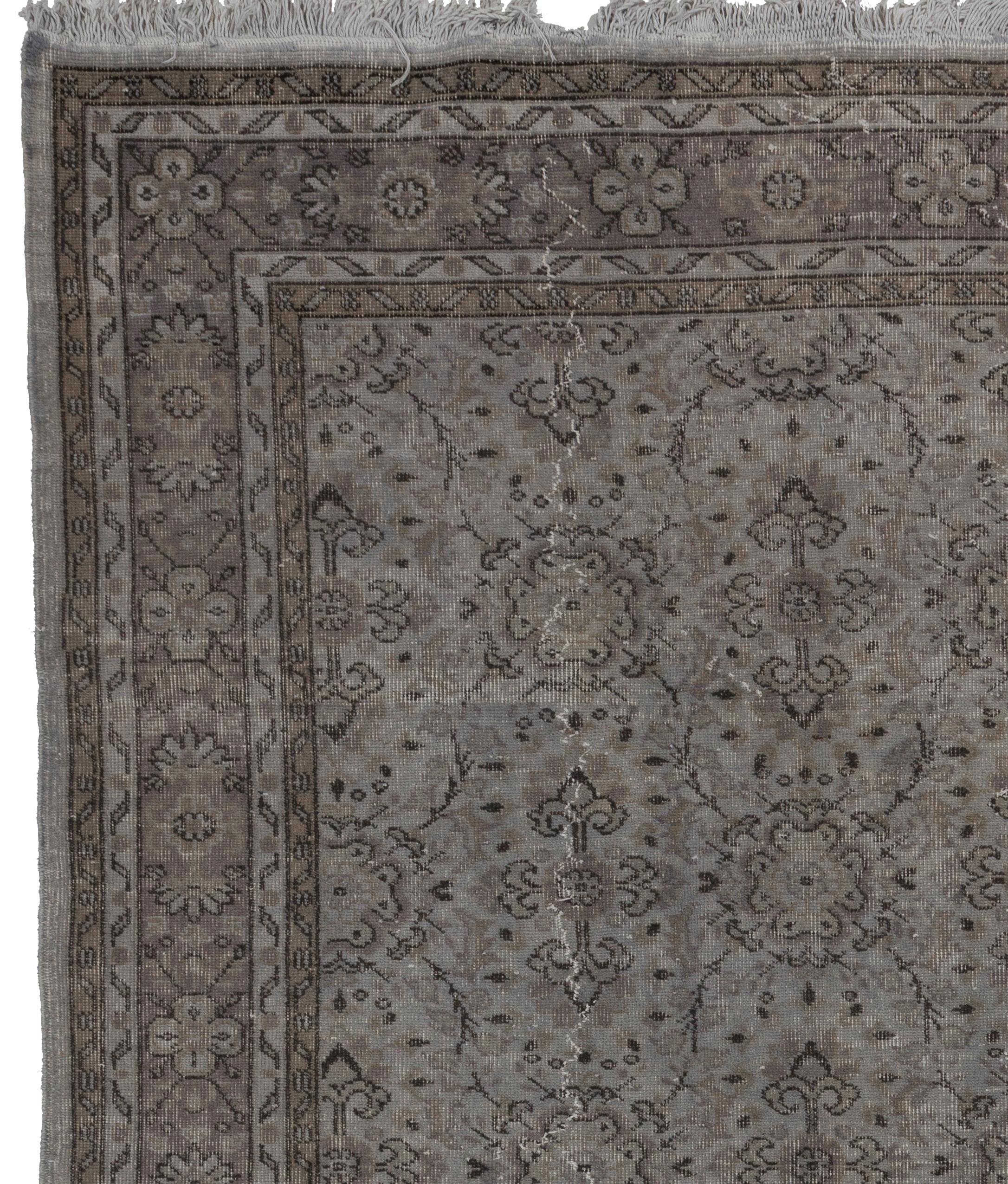 A vintage handmade Turkish area rug over-dyed in gray with an all-over floral design great for contemporary interiors. The rug is finely hand-knotted, professionally washed and has low wool pile on cotton foundation. It is sturdy and can be used on