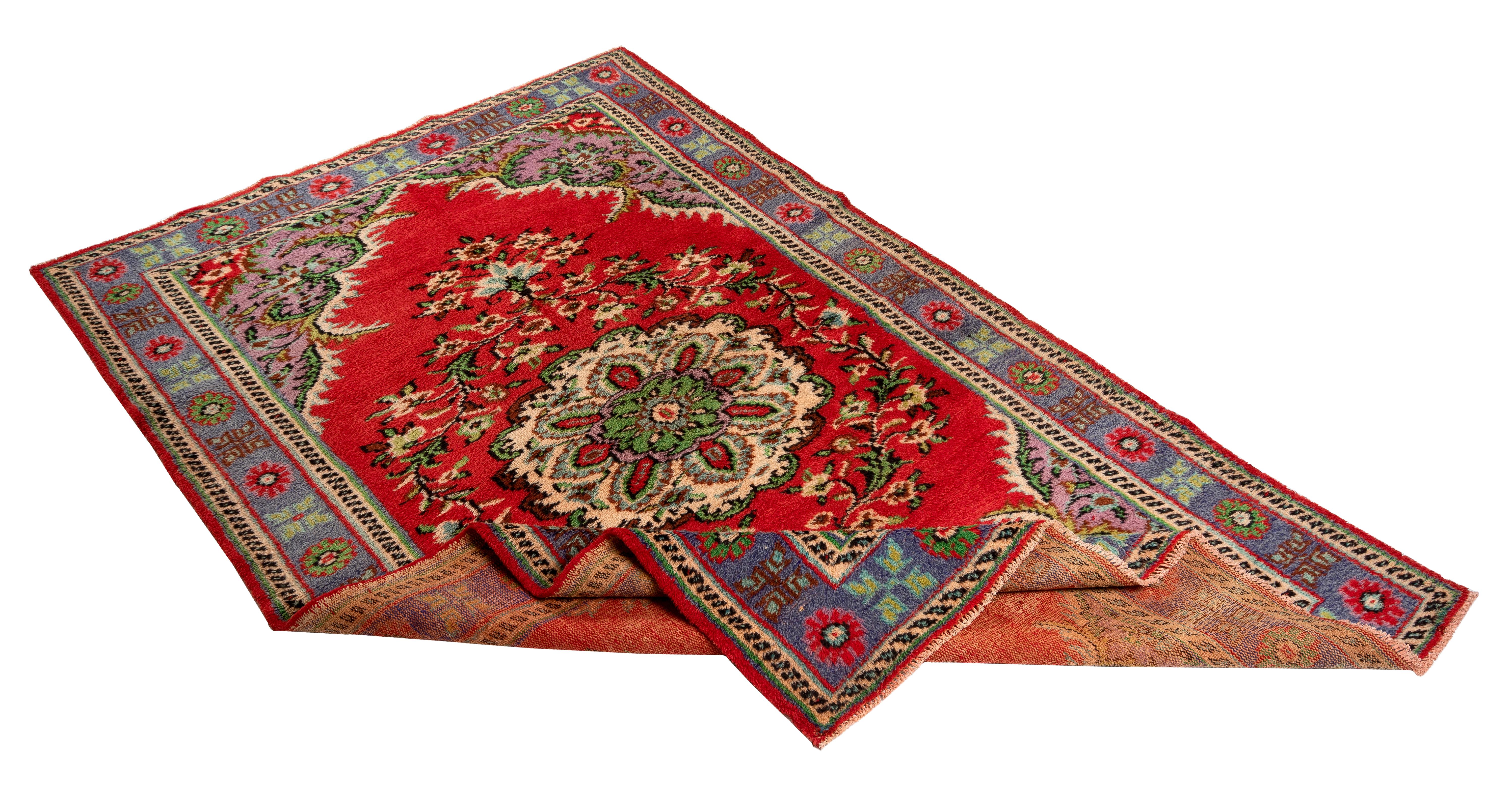 A finely hand-knotted vintage Turkish carpet from 1960s featuring a floral medallion design ivory, mint green and celadon green against a vivid red field. Corner pieces in lavender finished with scrolling leaves in bright emerald green and the main