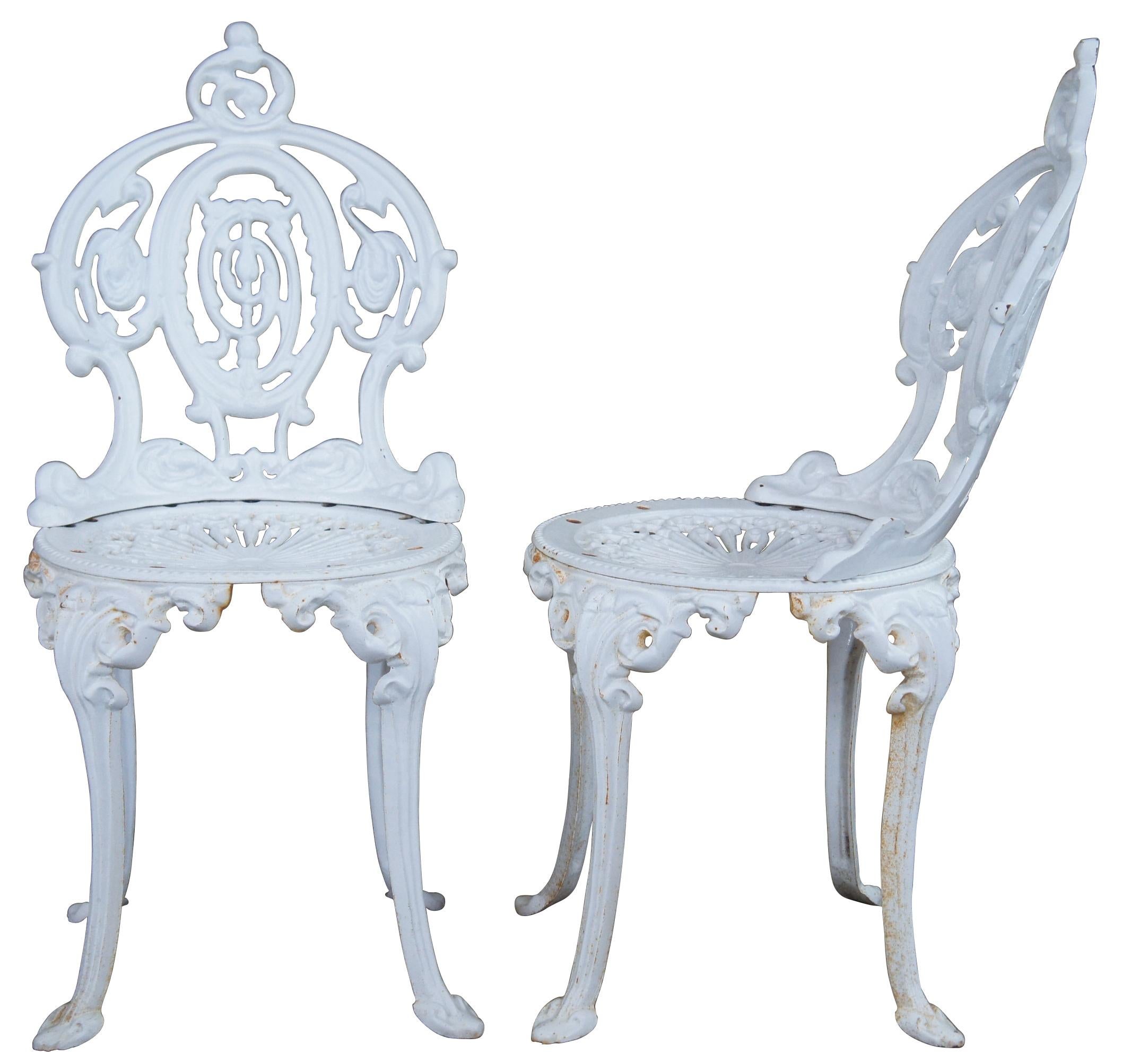 Seven antique French cast iron patio / garden / bistro chairs. Made of cast iron featuring an ornate design with crest and filigree seat. Very heavy.
 
