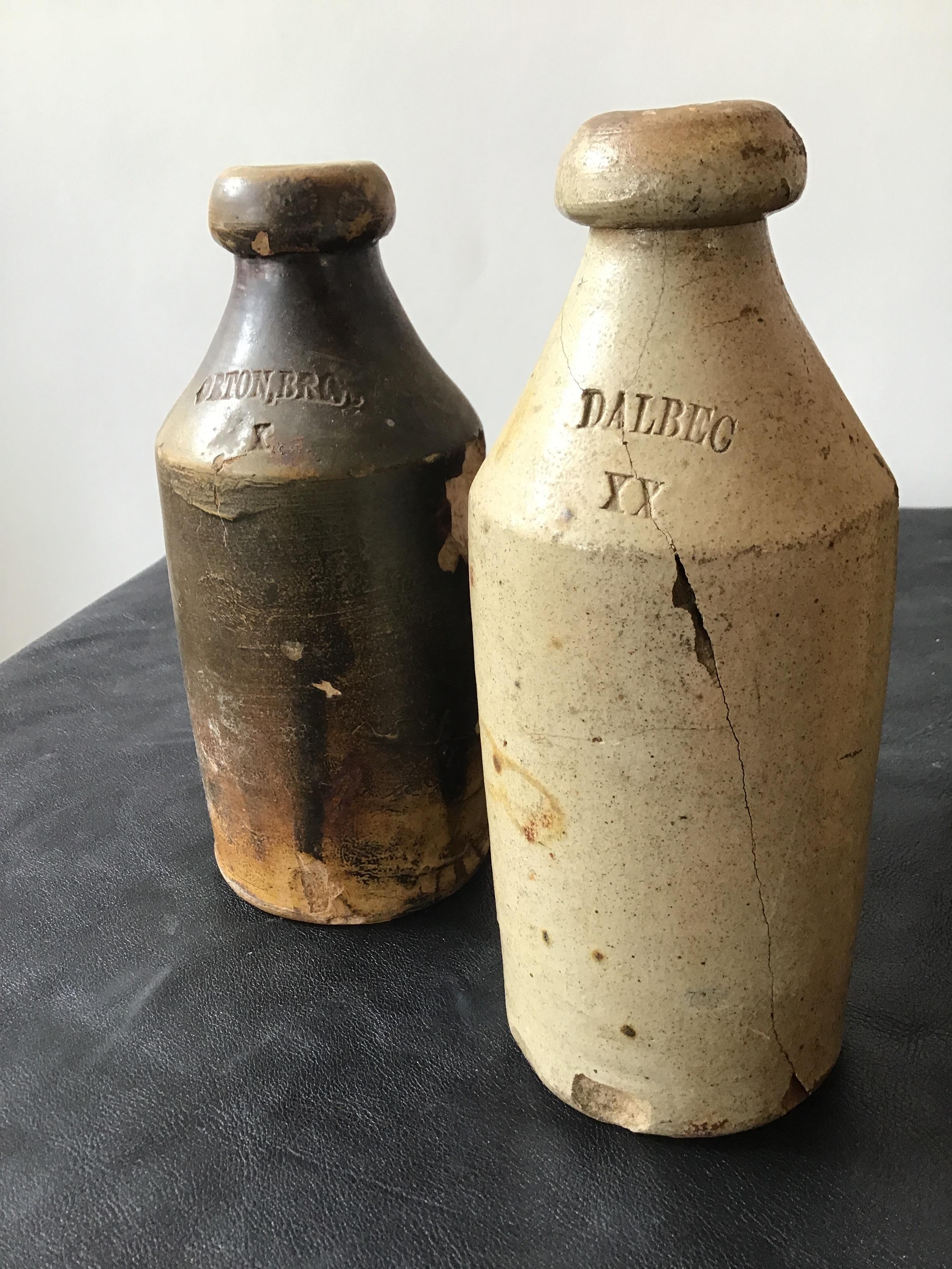 7 antique stoneware gin bottles. Chips, cracks in bottles.
