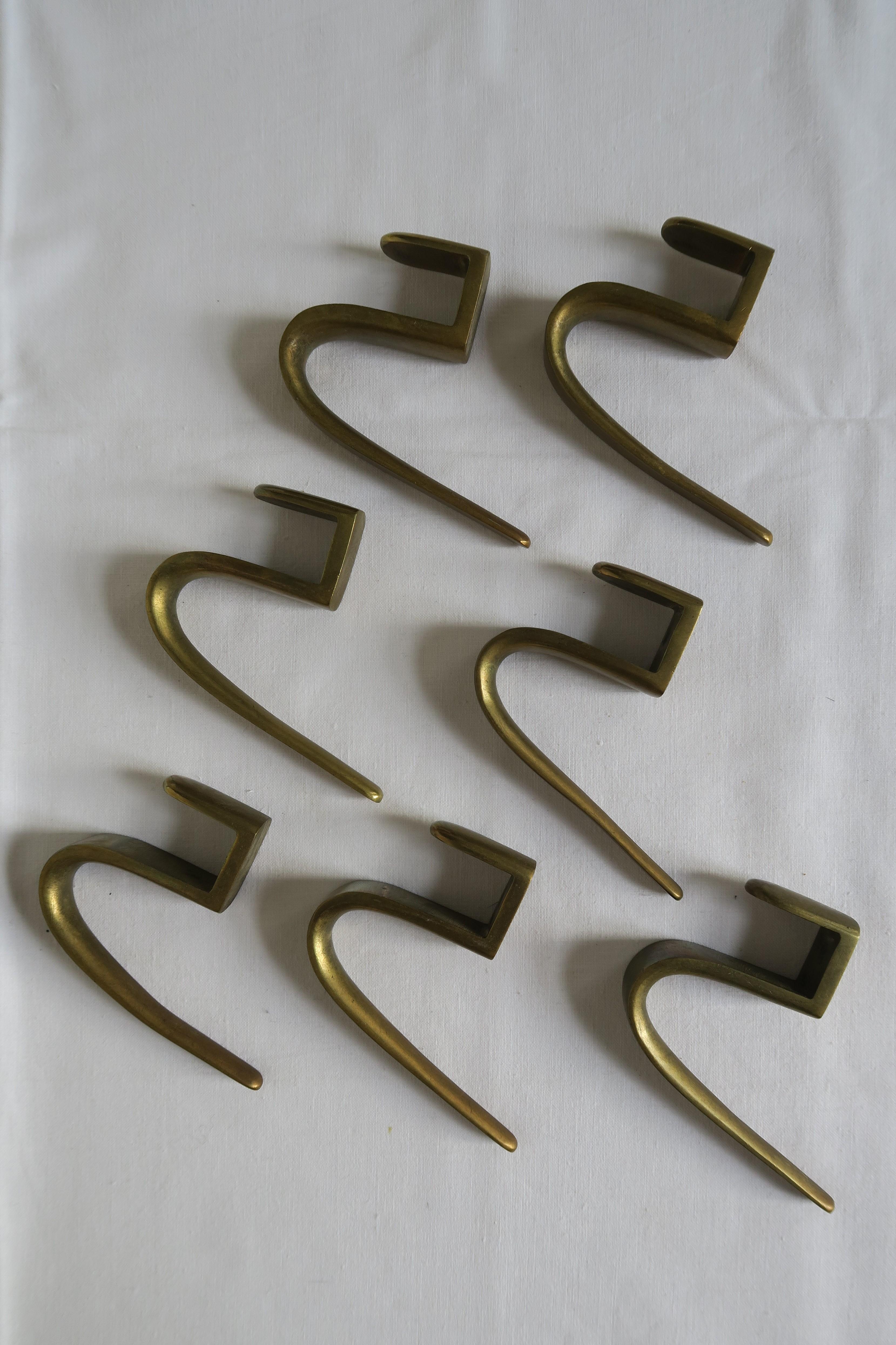 On offer are 7 massive brass coat hooks. They were designed by Carl Auböck in the 1950s and produced manually by his infamous Austrian Werkstätte.
Their shape is beautifully sloped and all the edges are rounded. Time has given them a unique