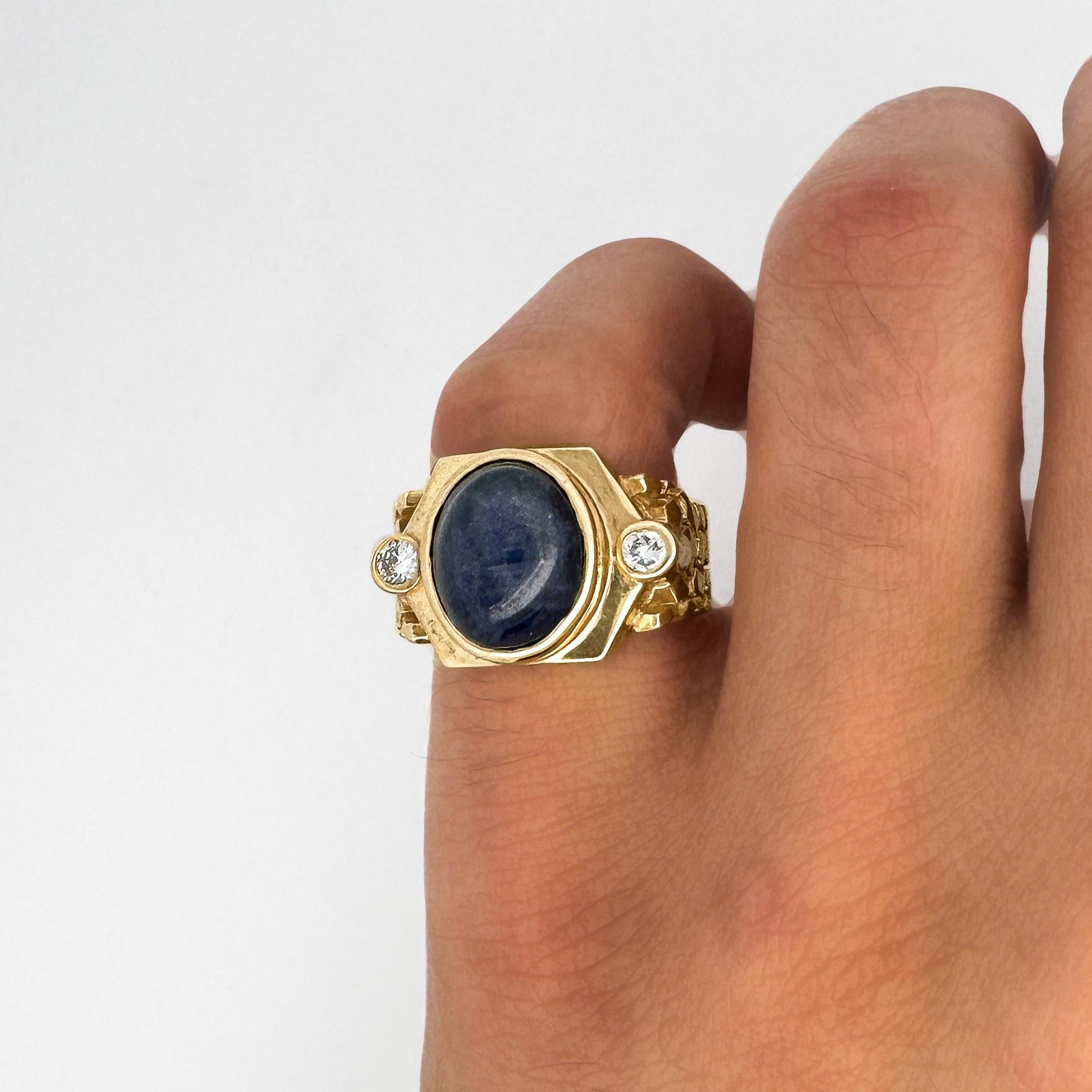Dieser kühne Herrenring im Nugget-Stil aus 14 Karat Gelbgold enthält einen 7-karätigen blauen Sternsaphir-Cabochon, der von 0,20 Karat runden Brillanten akzentuiert wird. Ring Größe 8,75, verstellbar.

Einzelheiten:
Artikel Typ: Nugget Style