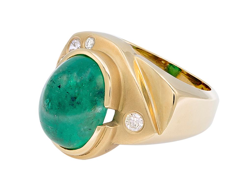 A spectacular ring that features a cabochon emerald. The emerald weighs approximately 7 carats. Around it is a constellation of 4 round diamonds. 

All set in 18K yellow gold material. Stamped 18K

This ring is truly one statement piece. Could be