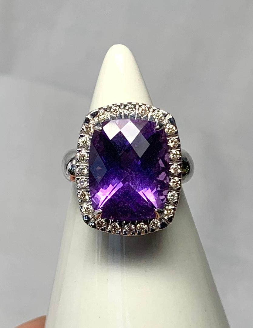 A stunning Cocktail Ring with a central 7.35 Carat Checkerboard Cut Rectangular Siberian Amethyst of gorgeous color and cut.  The Amethyst is surrounded by a halo of 24 sparkling white Diamonds.  The Amethyst is the radiant royal purple color that