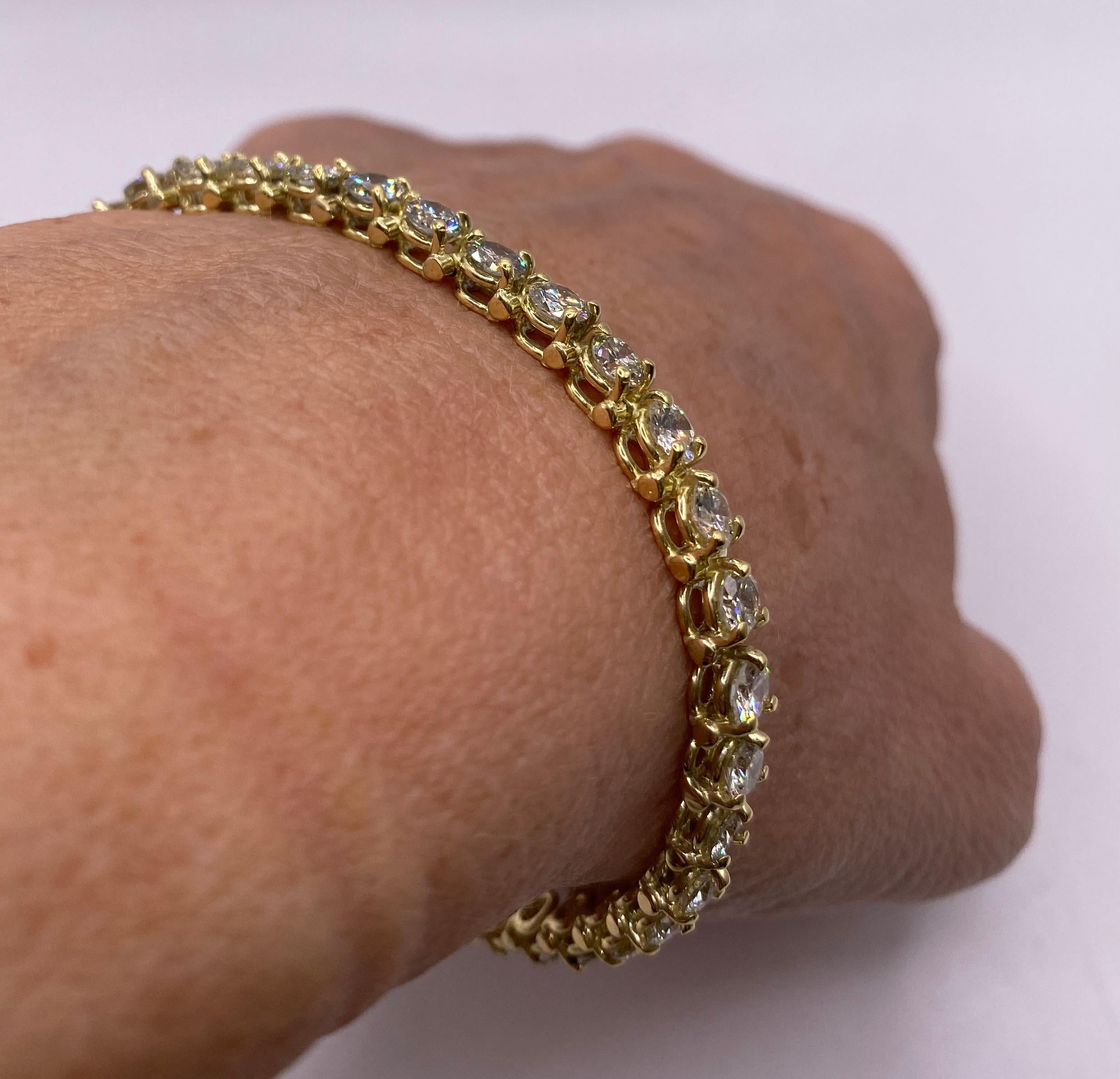 Approximate 7 carat total weight H VS Diamond 18k yellow gold tennis bracelet with safety clasp. Length 7