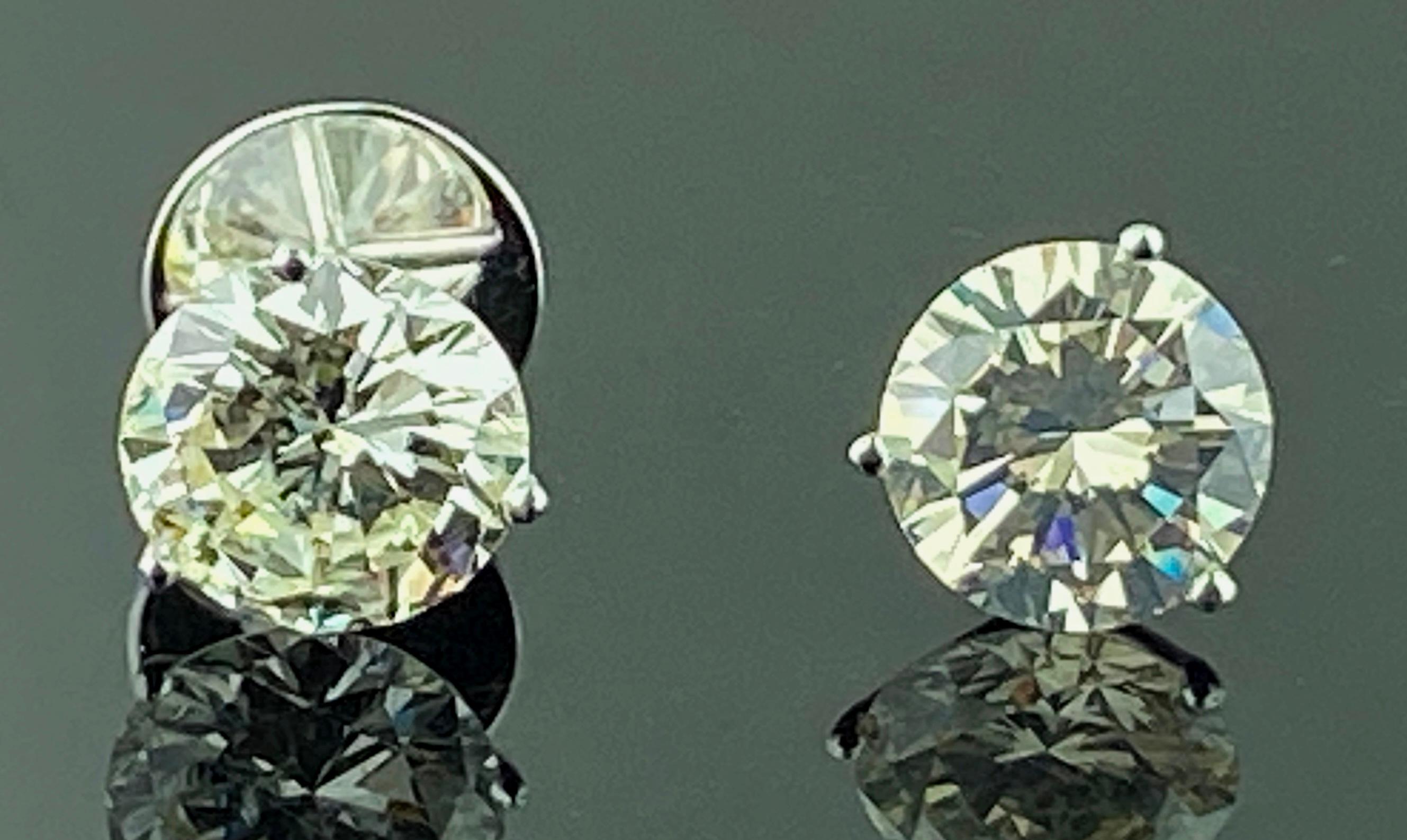 Set in 18 karat white gold are two round Brilliant Cut Diamond Stud earrings.  One is 7.19 carats, Color: Q-R, Clarity: SI-1, GIA Report #1196482822.  The other is 7.87 carats, Color: M, Clarity: I-1, GIA Report # 1192482832.