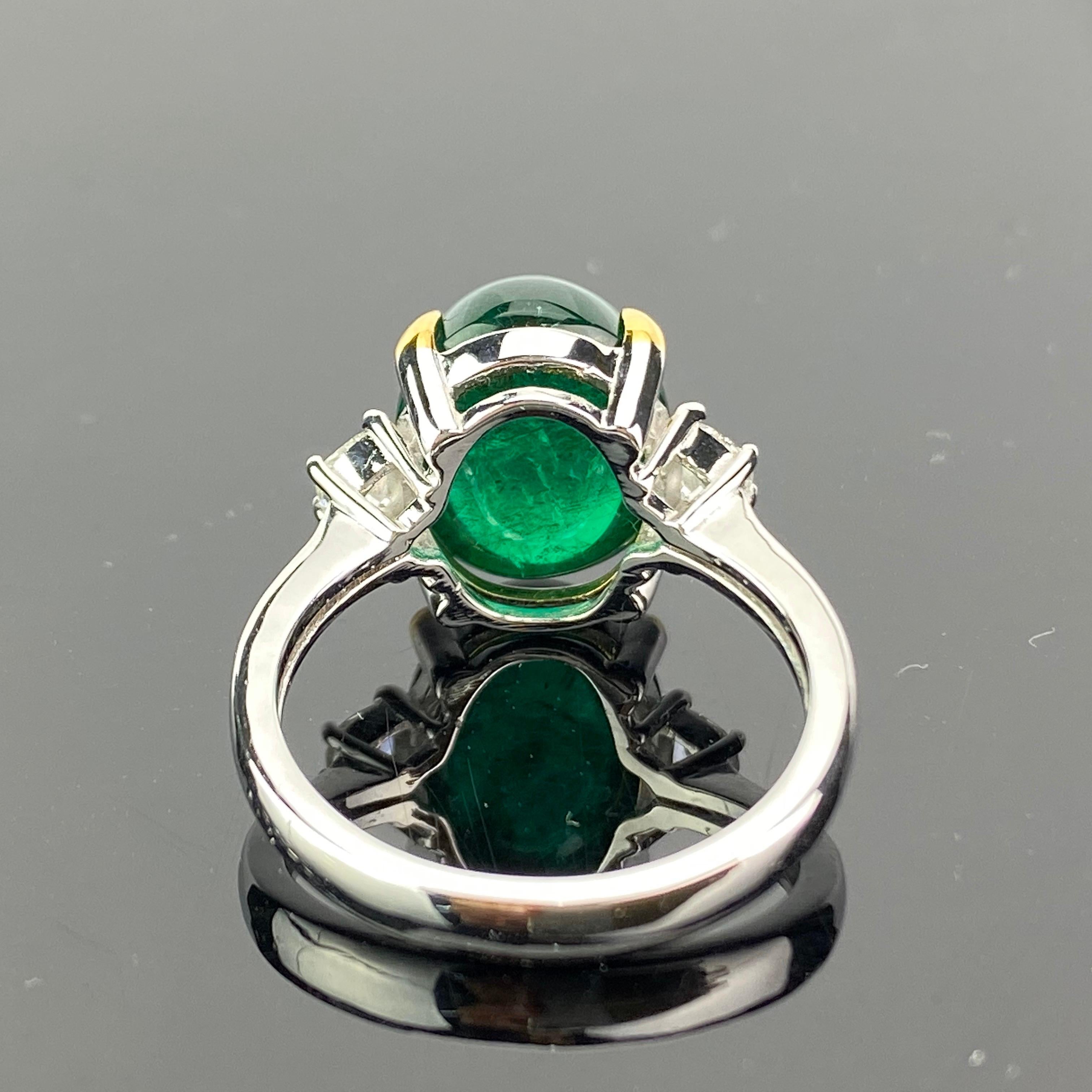 A beautiful three-stone engagement ring, with a 7.00 carat lustrous and transparent Zambian Emerald cabochon centre stone and 2 half-moon side stone diamonds; all set in 18K white gold. Currently a ring size US 6, but we can resize the ring for you