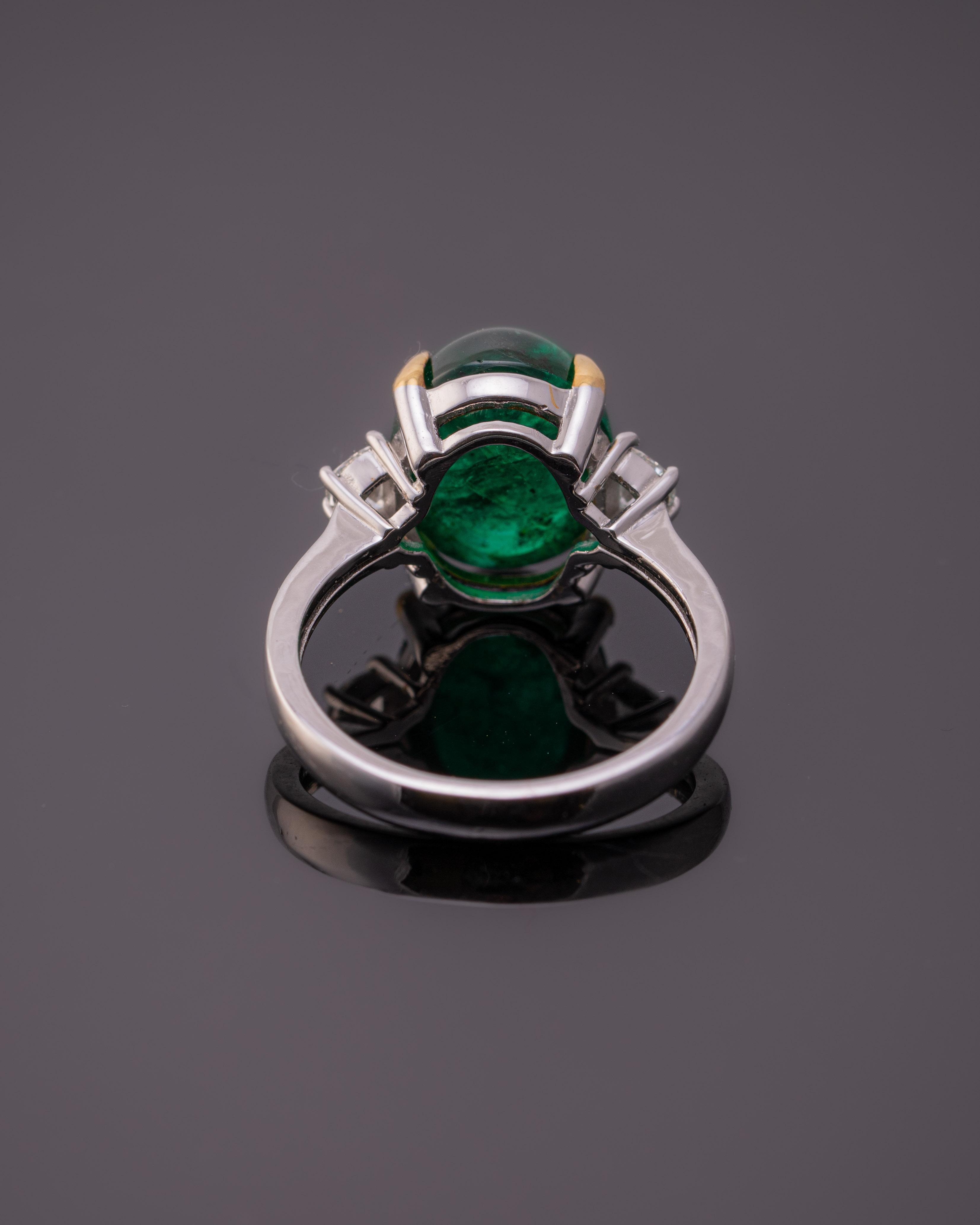 A classic 7 carat Zambian Emerald and 0.23 carat half-moon shaped White Diamond three-stone engagement ring. The Emerald cabochon is transparent, with a beautiful vivid green color - the stone is not treated/dyed and is absolutely natural. The
