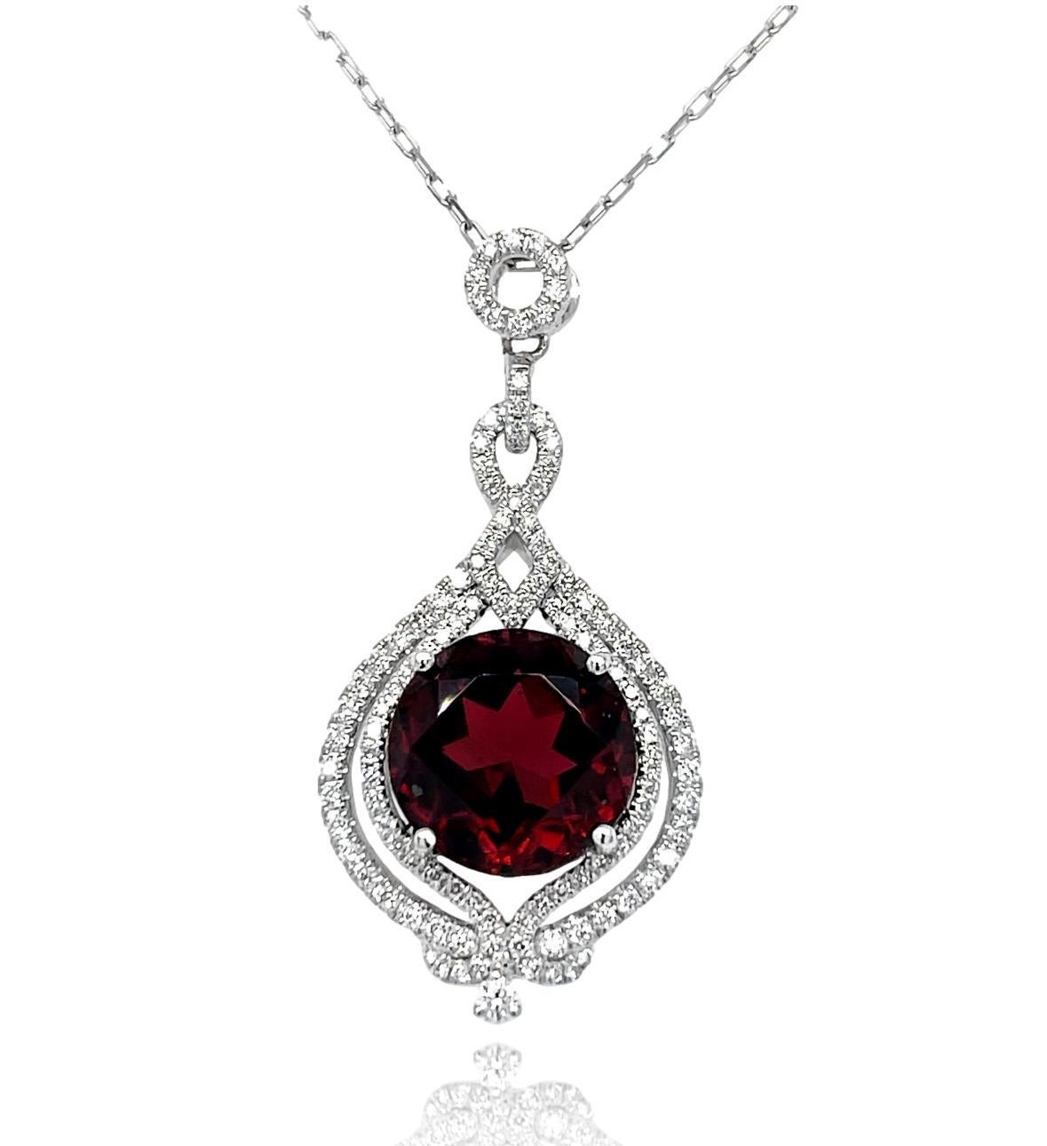 This stunning pendant has a deep red 12mm round Garnet set in 18 karat white gold with 4 prong setting. There is a halo of 116 brilliant cut round sparkling diamonds surrounding the Garnet for a delicate accent. This pendant will be shipped in a