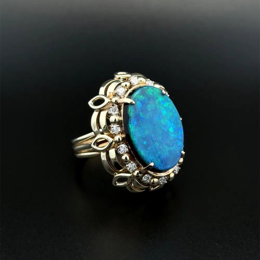 Einfach schön! Eleganter und fein ausgearbeiteter Cocktailring mit ovalem Opal und Diamant in Gold. Handbesetzt mit einem sicher eingebetteten 7 Karat Oval Opal Doublet umgeben von .42tcw Brillantschliff Diamanten. Handgefertigt in 18K Gelbgold.
