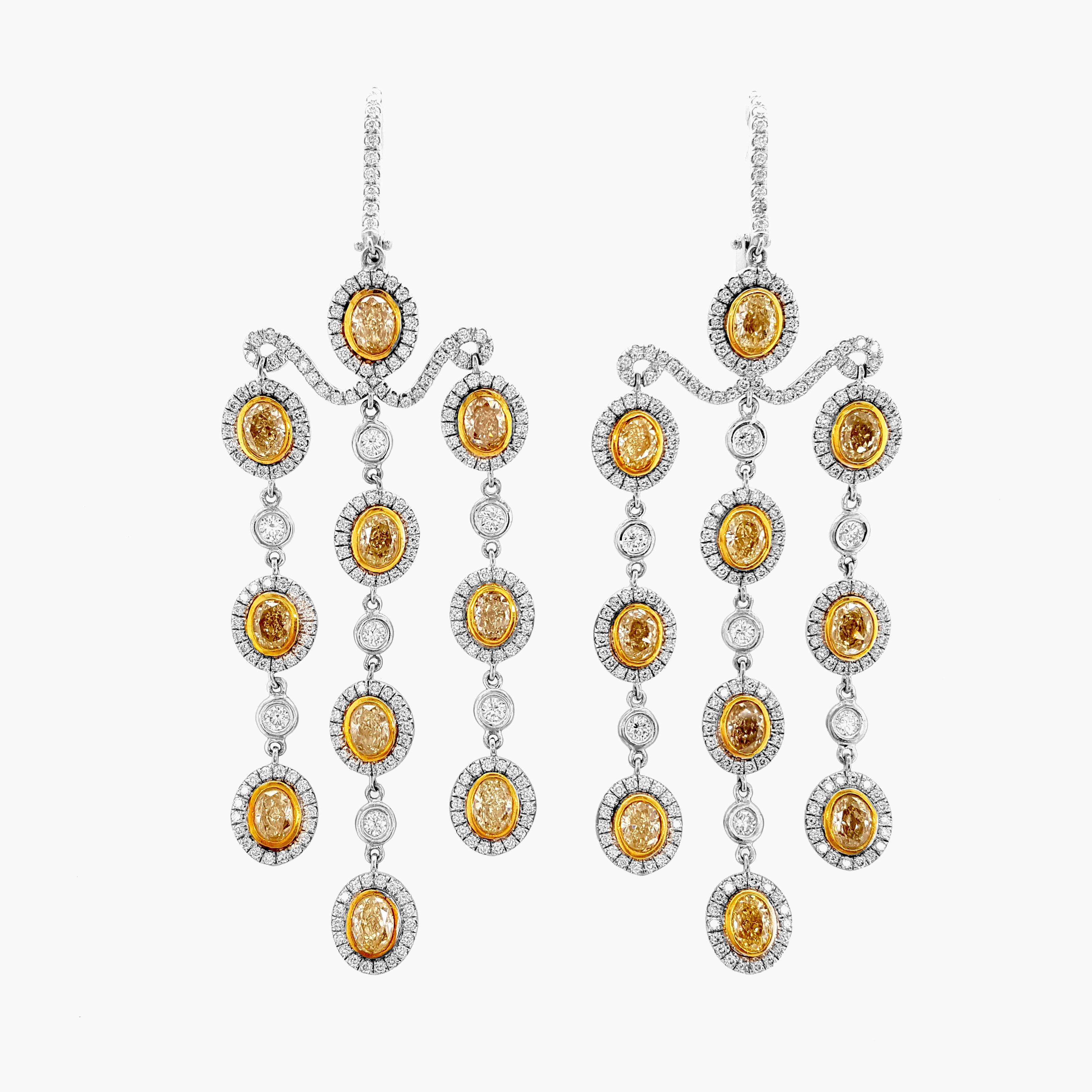Nous vous présentons notre exquise paire de pendants d'oreilles Chandelier, ornés d'une combinaison captivante de diamants jaunes et blancs de 7,23 carats. Fabriquées à la main et serties dans de l'or jaune et blanc 18 carats poli, ces boucles