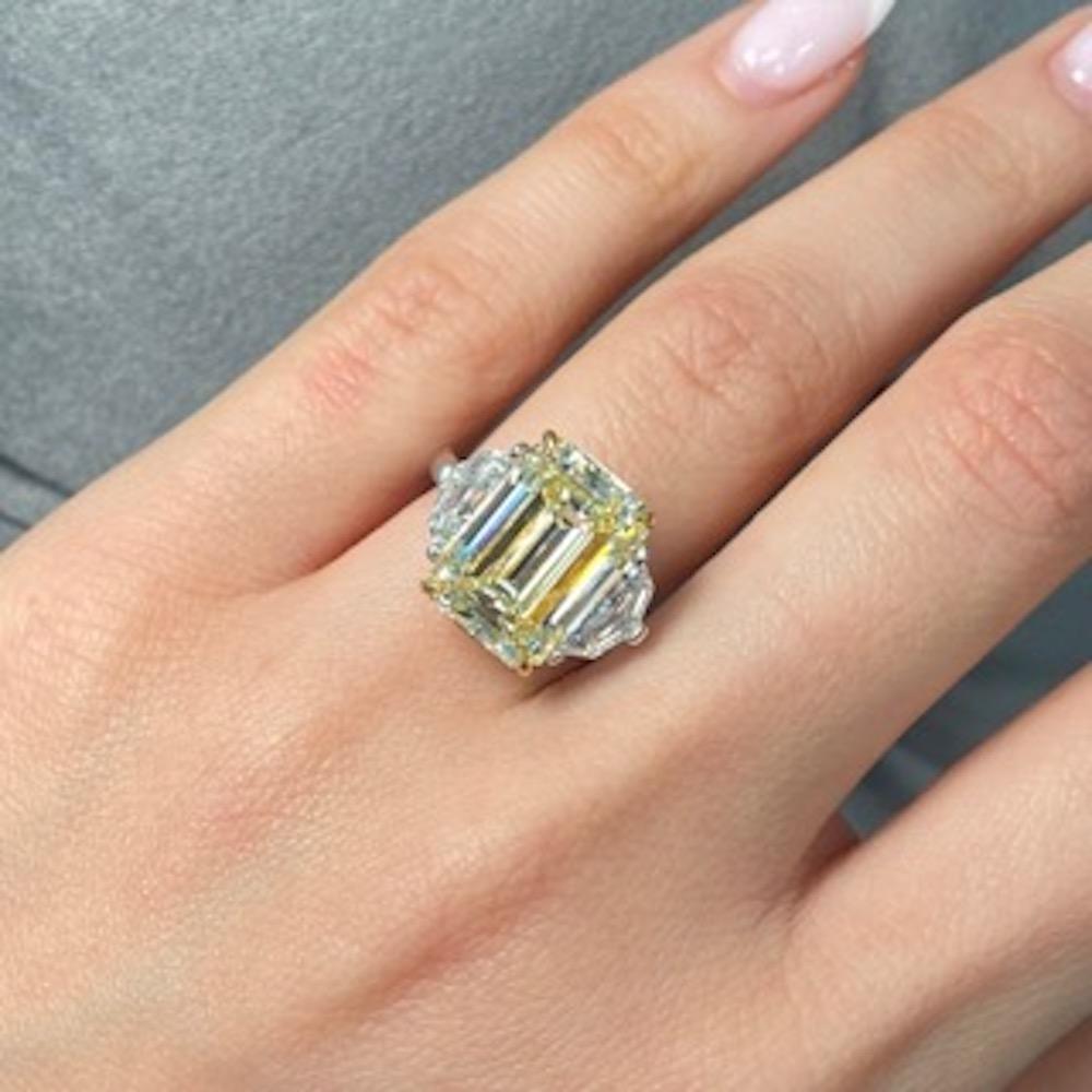 This stunning engagement ring features a breathtaking 7.36 carat emerald cut yellow diamond at its center, offering a warm, captivating light yellow hue within the W-X color range. The diamond’s VS1 clarity ensures exceptional brilliance and