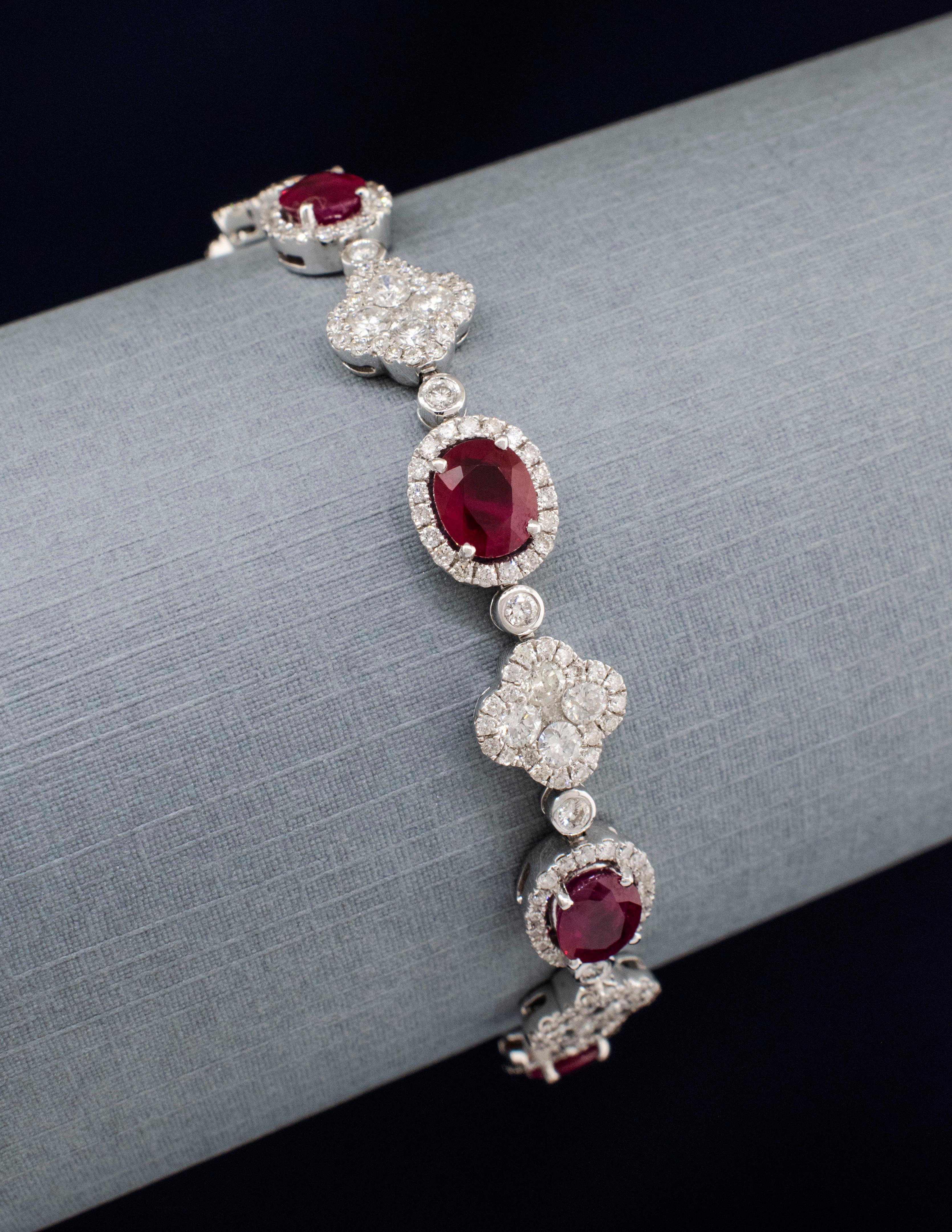 A Ladies Ruby and Diamond Bracelet made of 18 karat white gold. There are eight bright Pigeon Blood Natural Rubies in an oval brilliant cut with a total gem weight of approximately 7.14 carats. Each one has been carefully chosen to match for color,