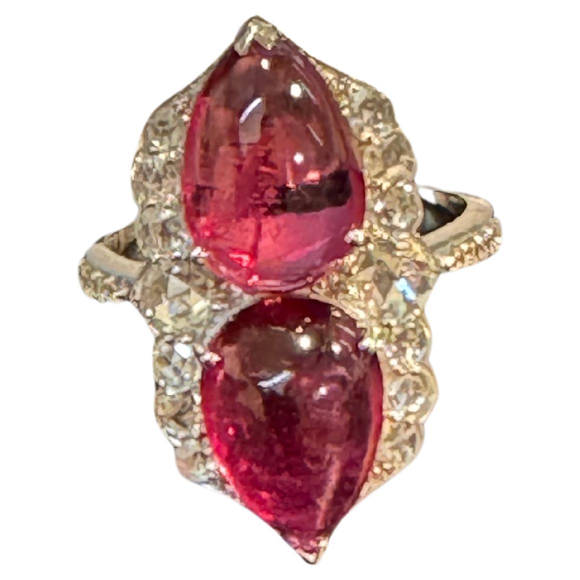Introducing a timeless classic, the Cocktail Ring features a stunning 7 Ct Finest Rubelite with 2 Cabochons in pear shape and 1 Carat Diamond set in 18 Kt White Gold. Crafted with exquisite detail, this piece weighs 5.3 grams and is currently a size